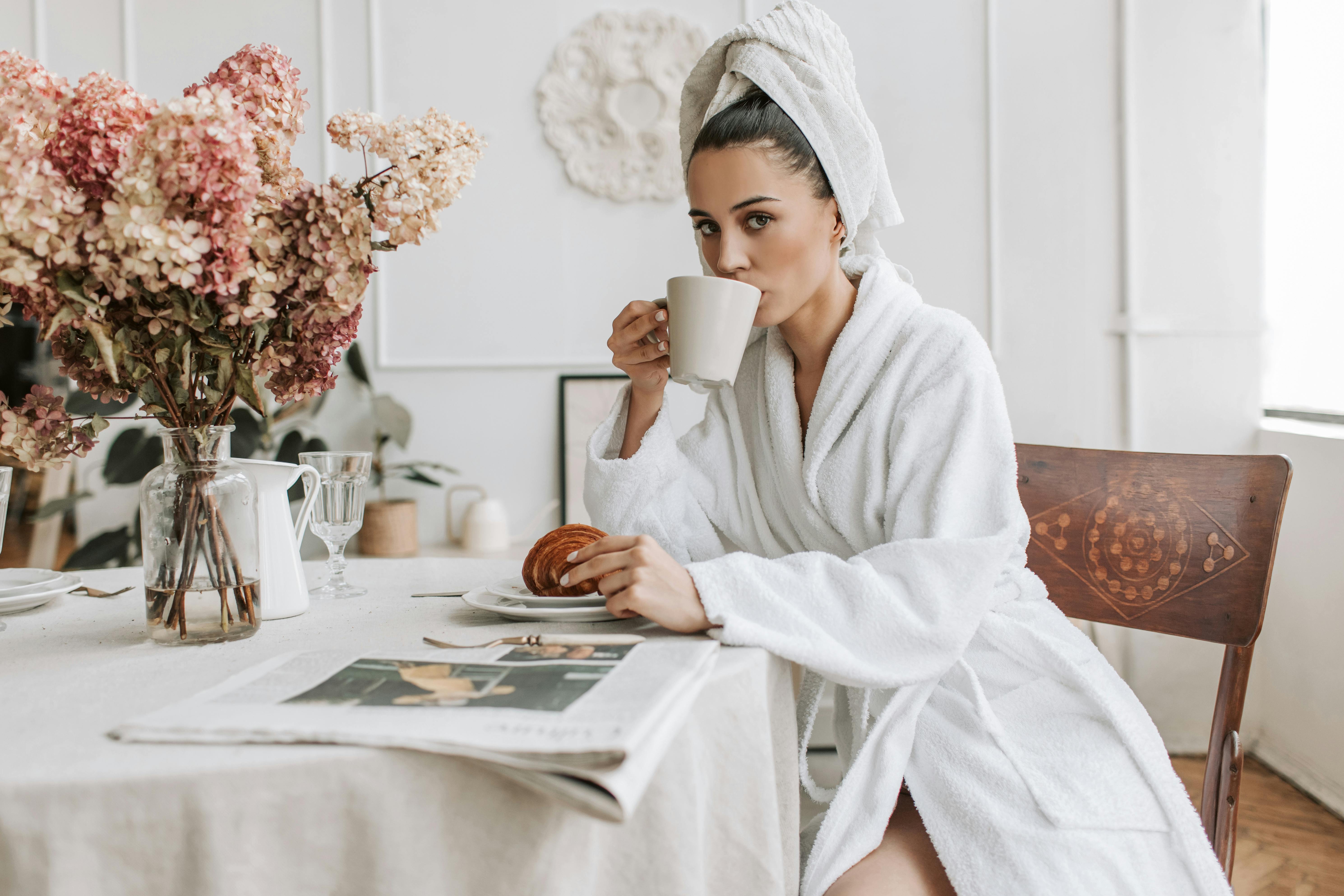 Une femme qui regarde devant elle en buvant un café | Source : Pexels