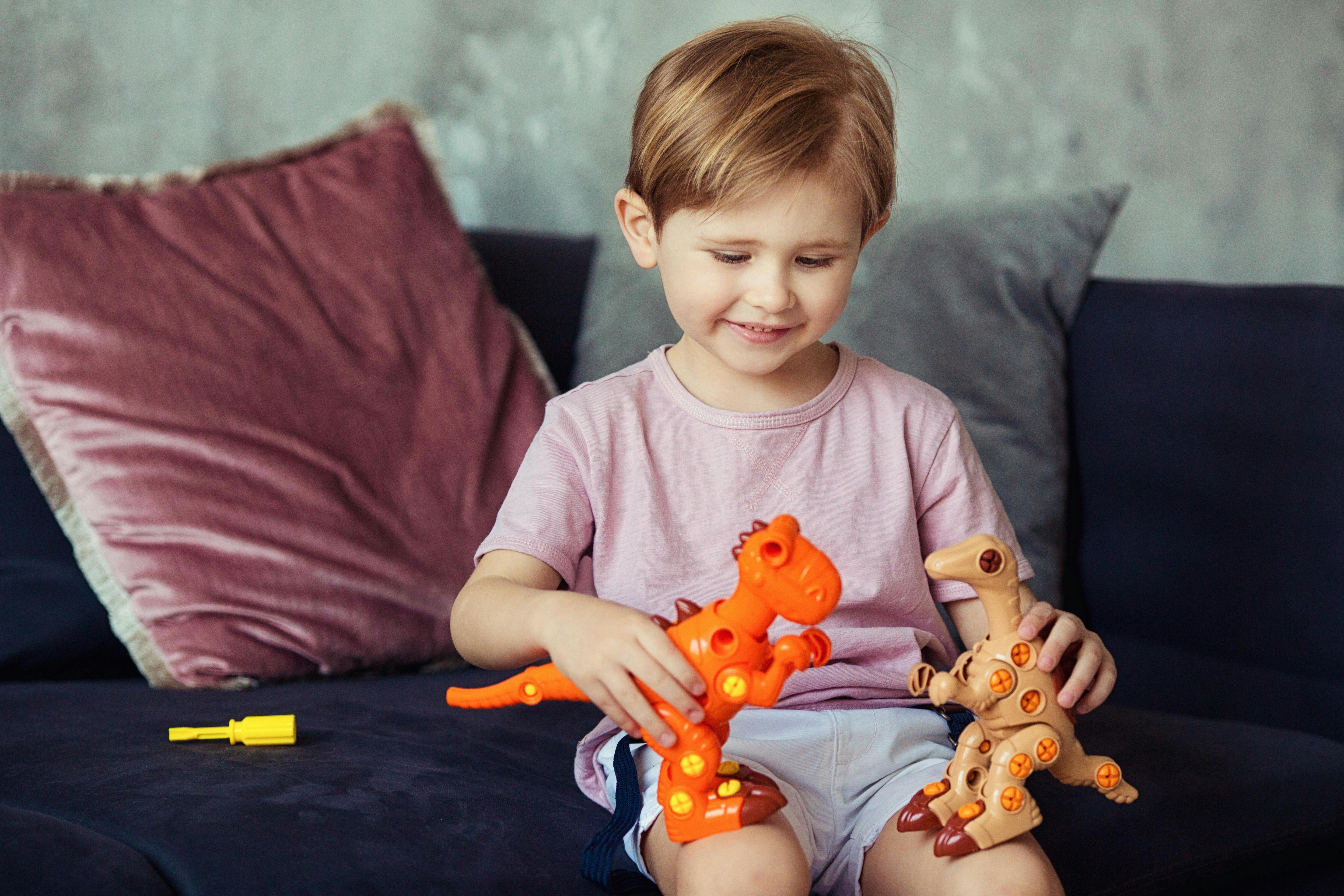 Un enfant jouant avec des jouets en forme de dinosaures | Source : Pexels