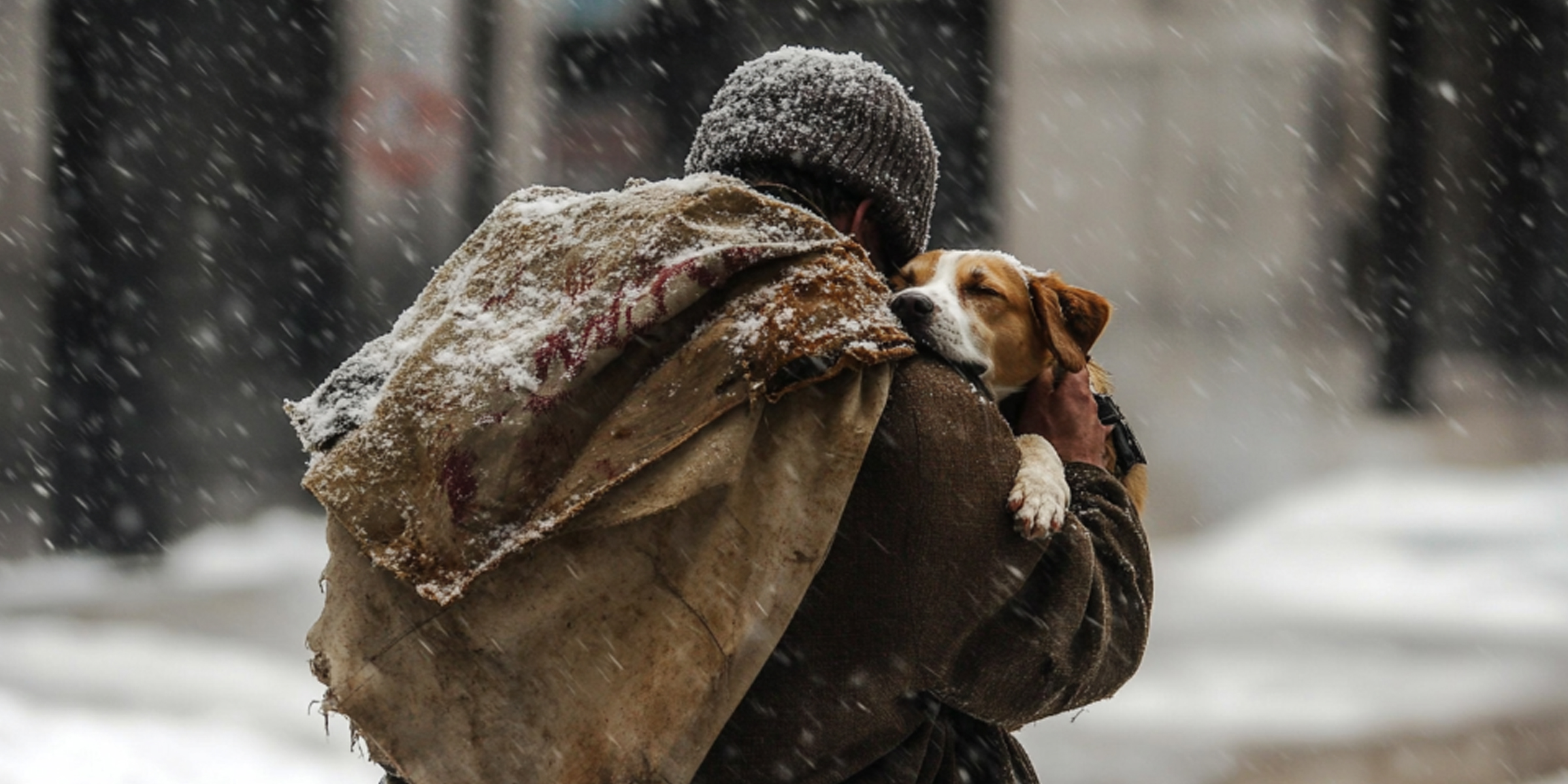 Un homme tenant un chien dans la neige | Source : Amomama