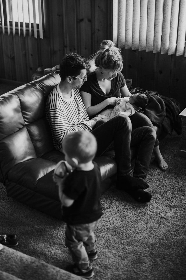 Photo en noir et blanc d'une famille dans un salon | Photo : Unsplash