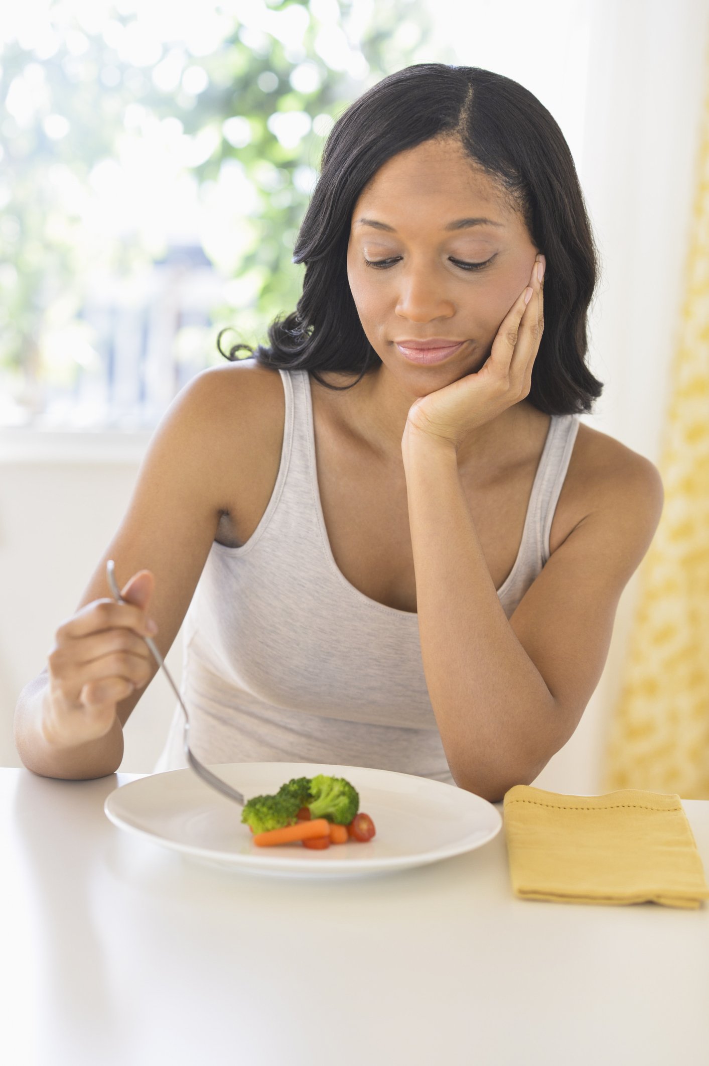 Photo d'une jeune femme mangeant des légumes | Photo : Getty Images