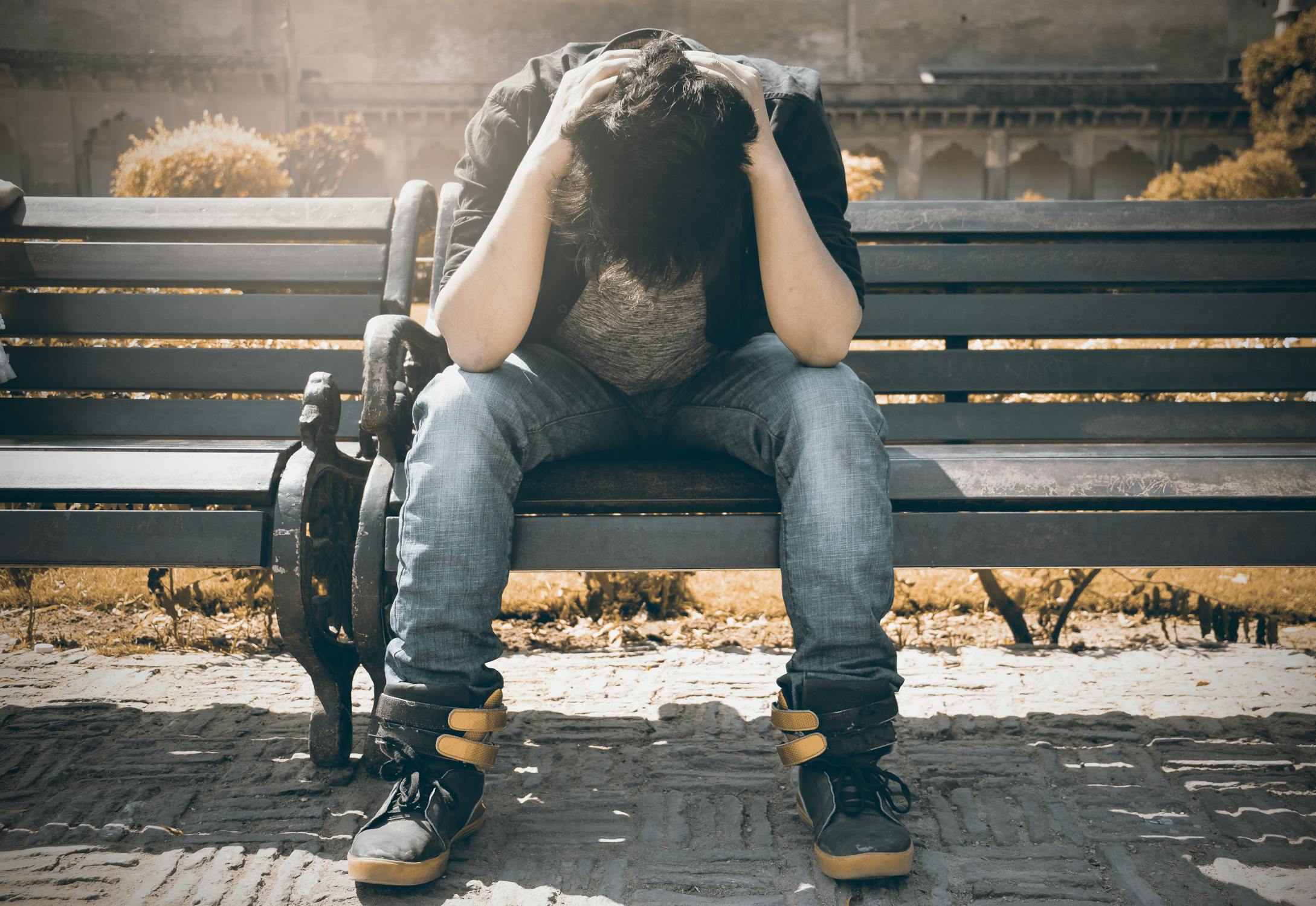 Un homme triste assis sur un banc | Source : Pexels