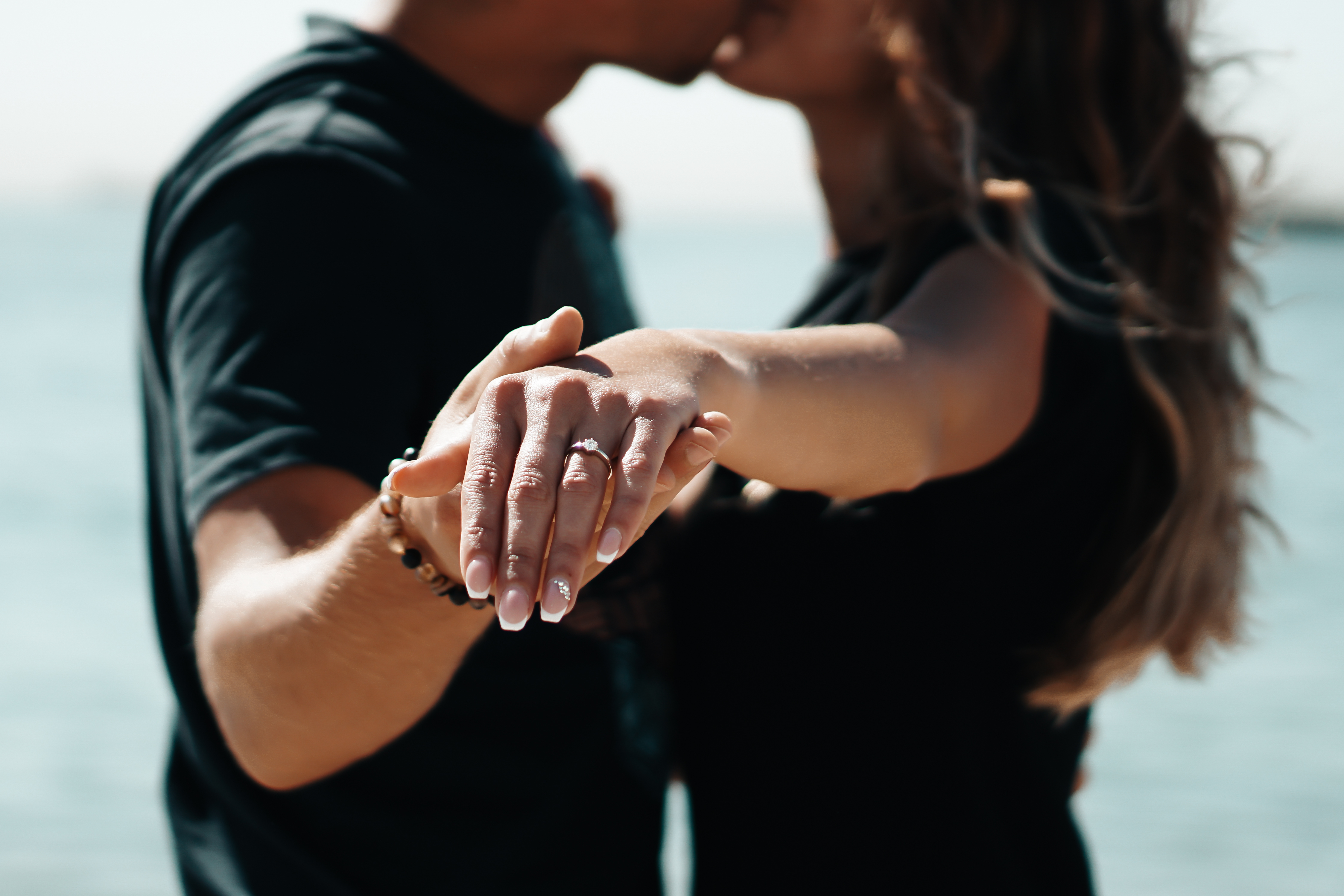Des fiancés s'embrassent et tendent leurs mains vers l'appareil photo | Source : Shutterstock