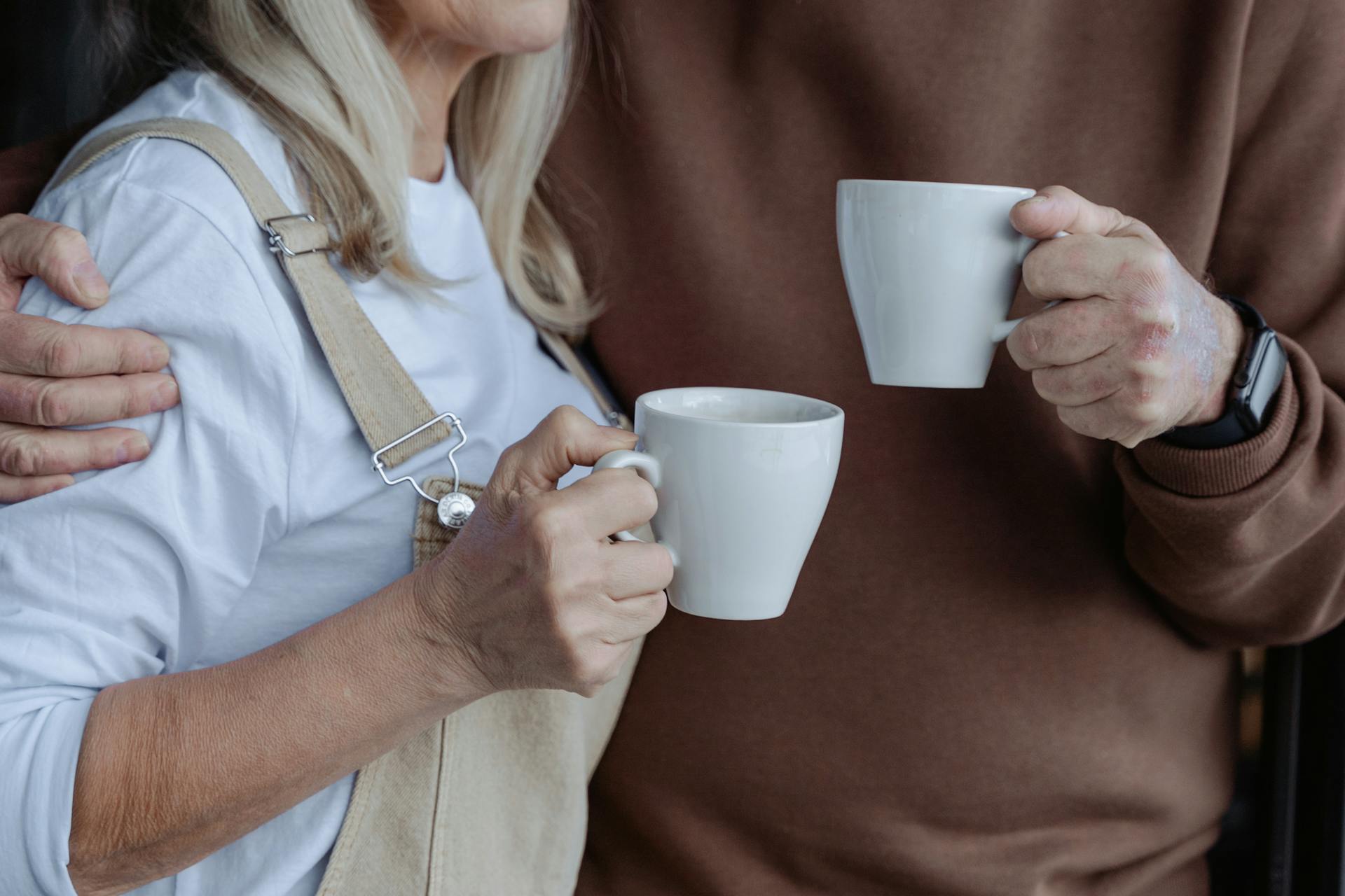 Un couple tenant des tasses blanches | Source : Pexels