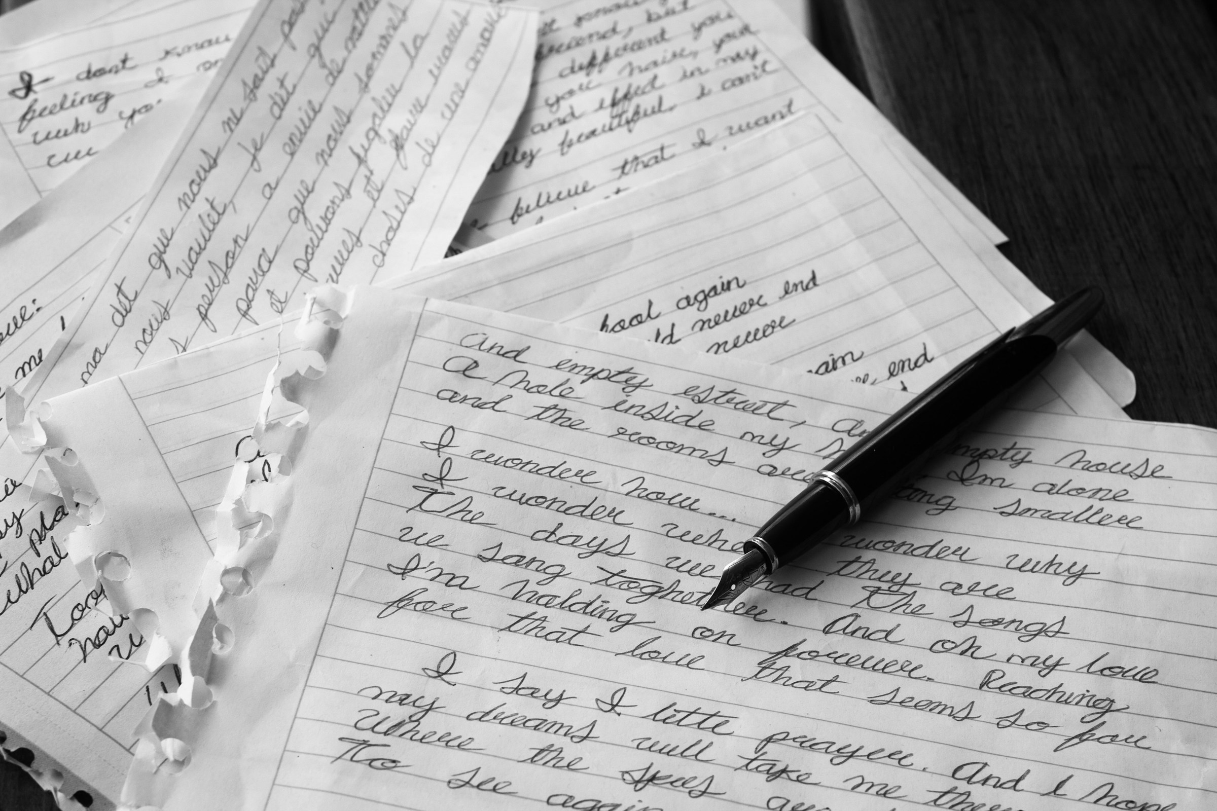 Un stylo posé sur des morceaux de papier blanc avec quelque chose d'écrit dessus | Source : Unsplash