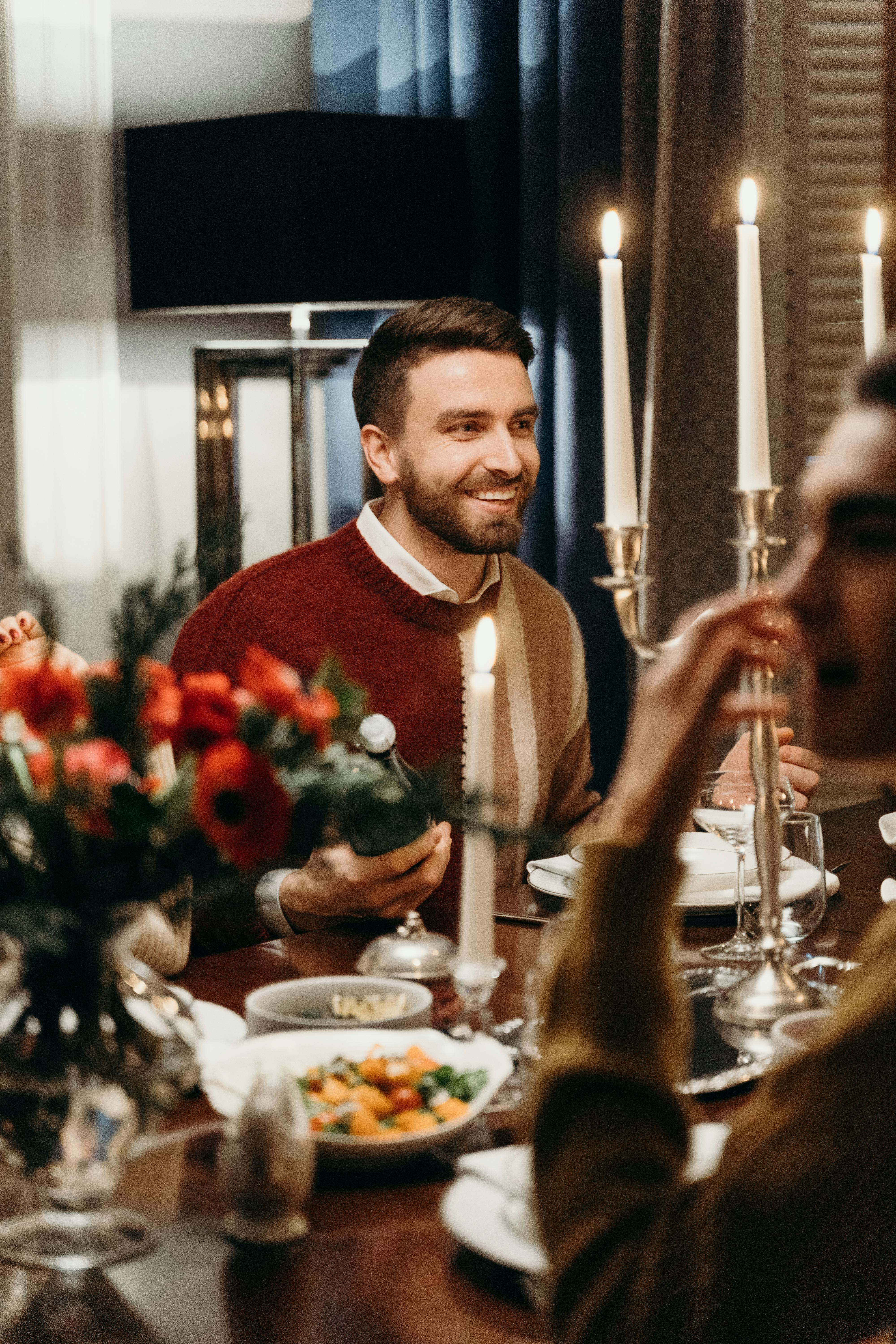 Un homme souriant à table | Source : Pexels