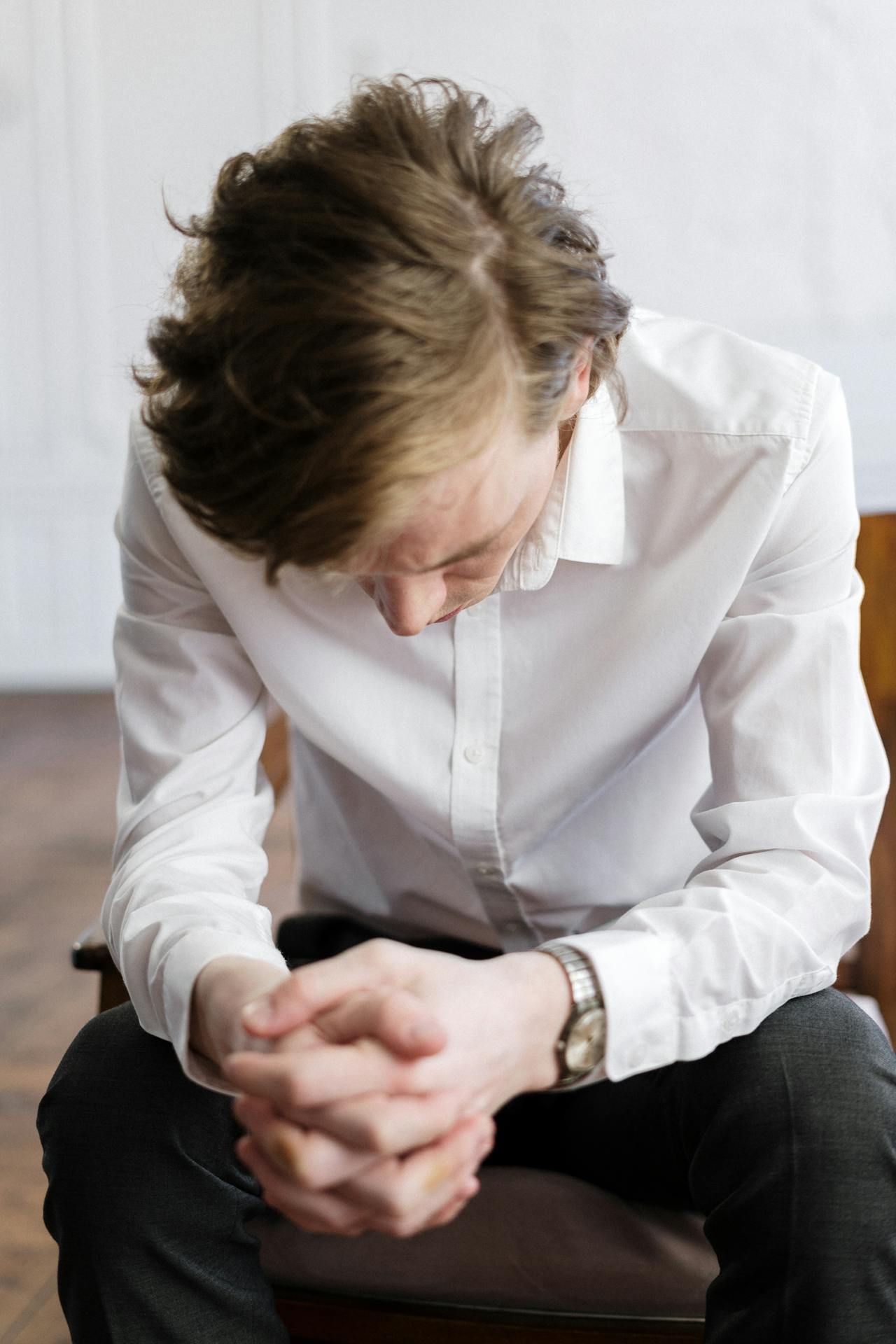 Un homme triste assis sur une chaise | Source : Pexels