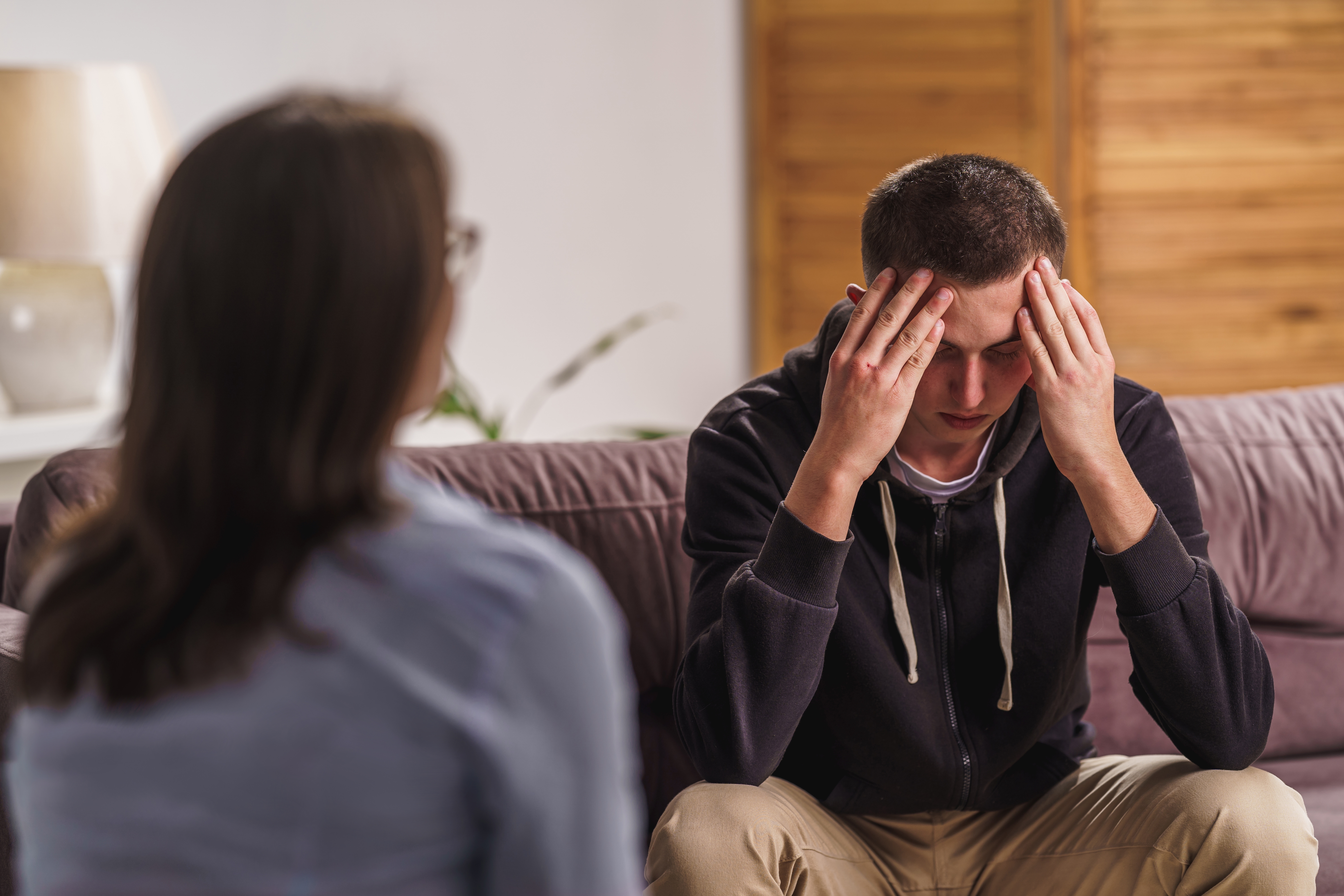 Un adolescent à l'air triste alors qu'il parle à une femme | Source : Shutterstock