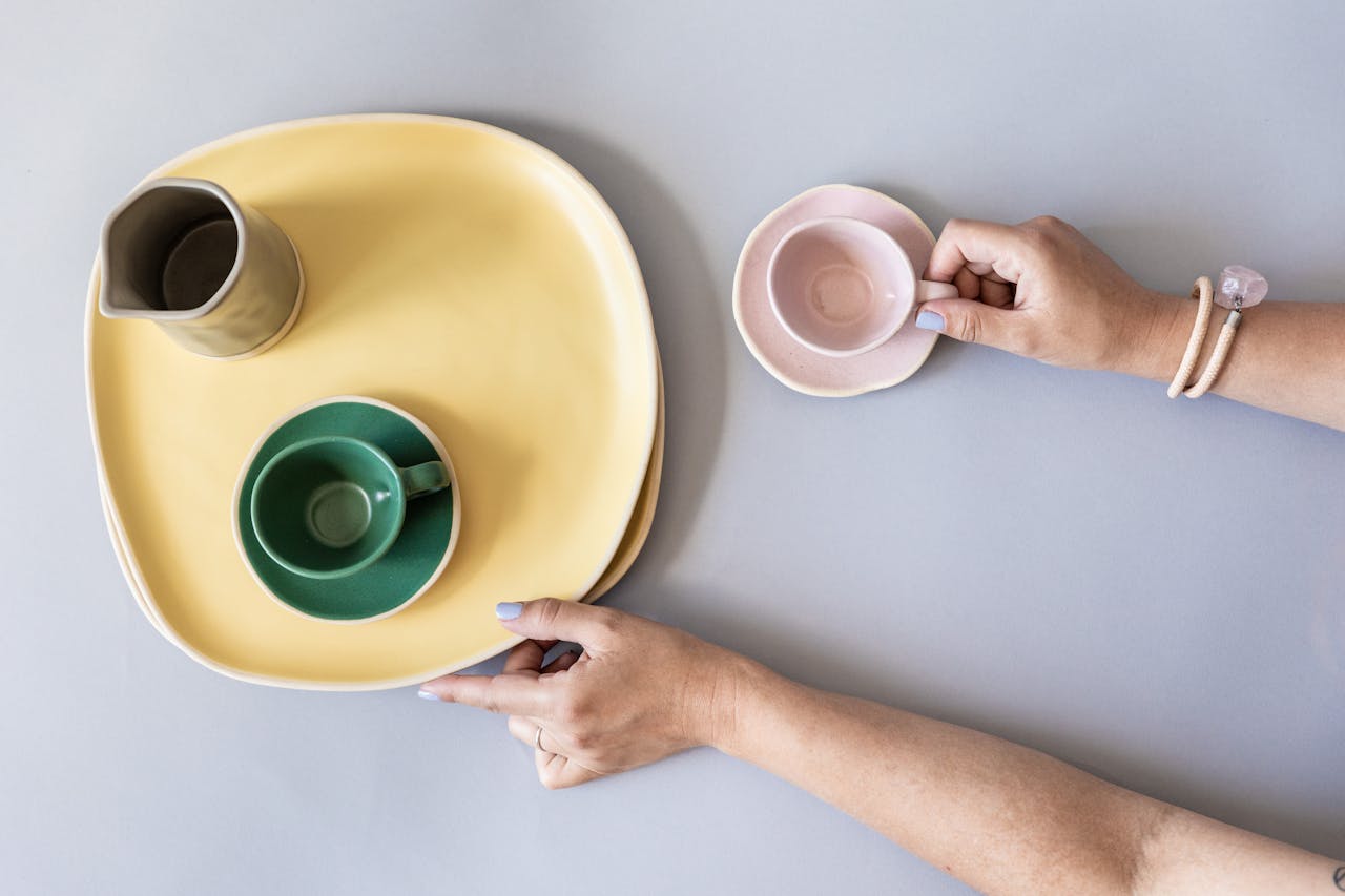 Une femme rassemblant des assiettes et des tasses vides | Source : Pexels