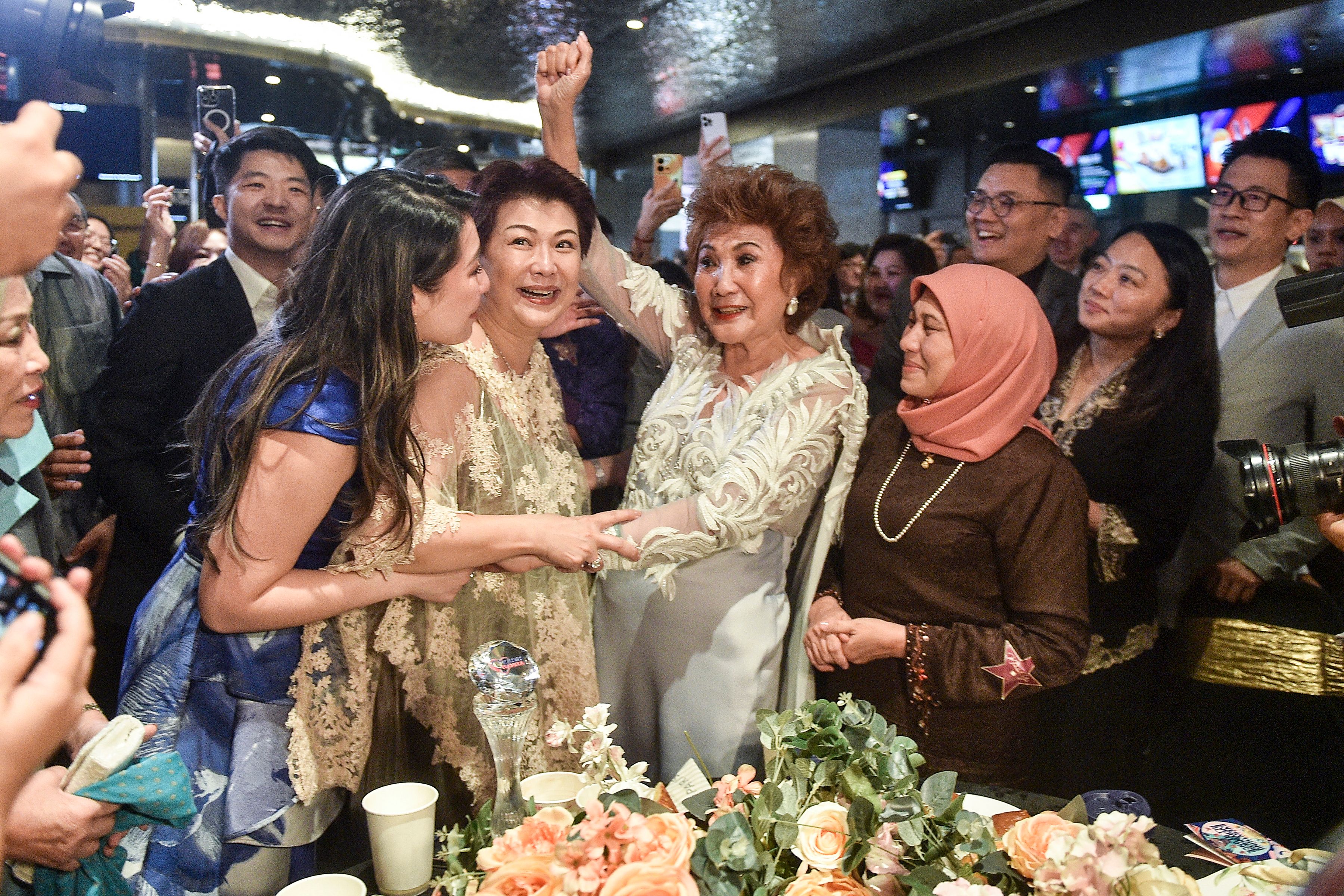 Janet Yeoh (au centre, à droite), mère de l'actrice Michelle Yeoh, célébrant la victoire de sa fille dans la catégorie "Meilleure actrice dans un rôle principal" lors de la 95e cérémonie des Oscars à Los Angeles, lors d'un événement à Kuala Lumpur le 13 mars 2023. | Source : Getty Images