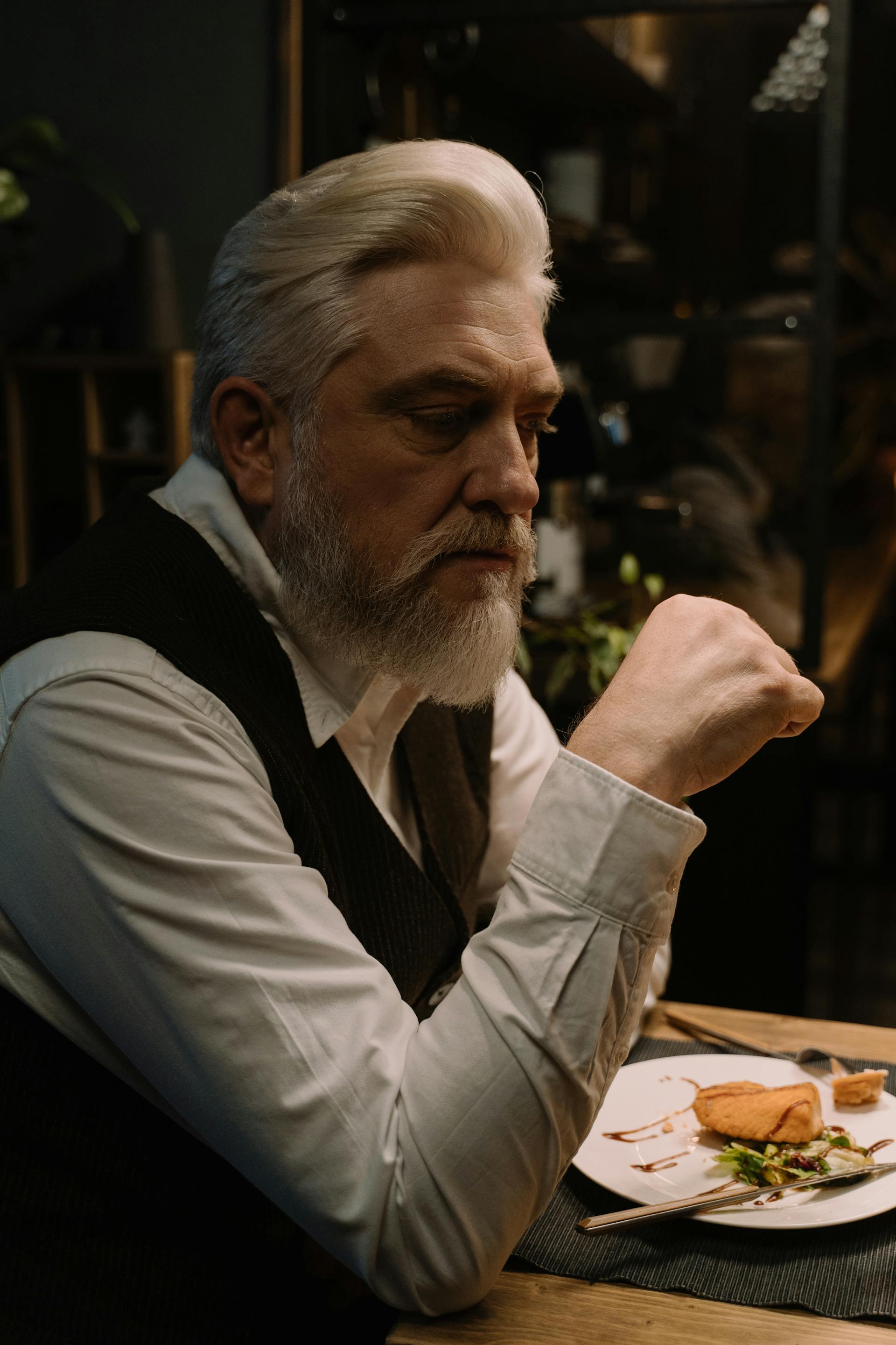 Un homme assis à une table de dîner | Source : Pexels