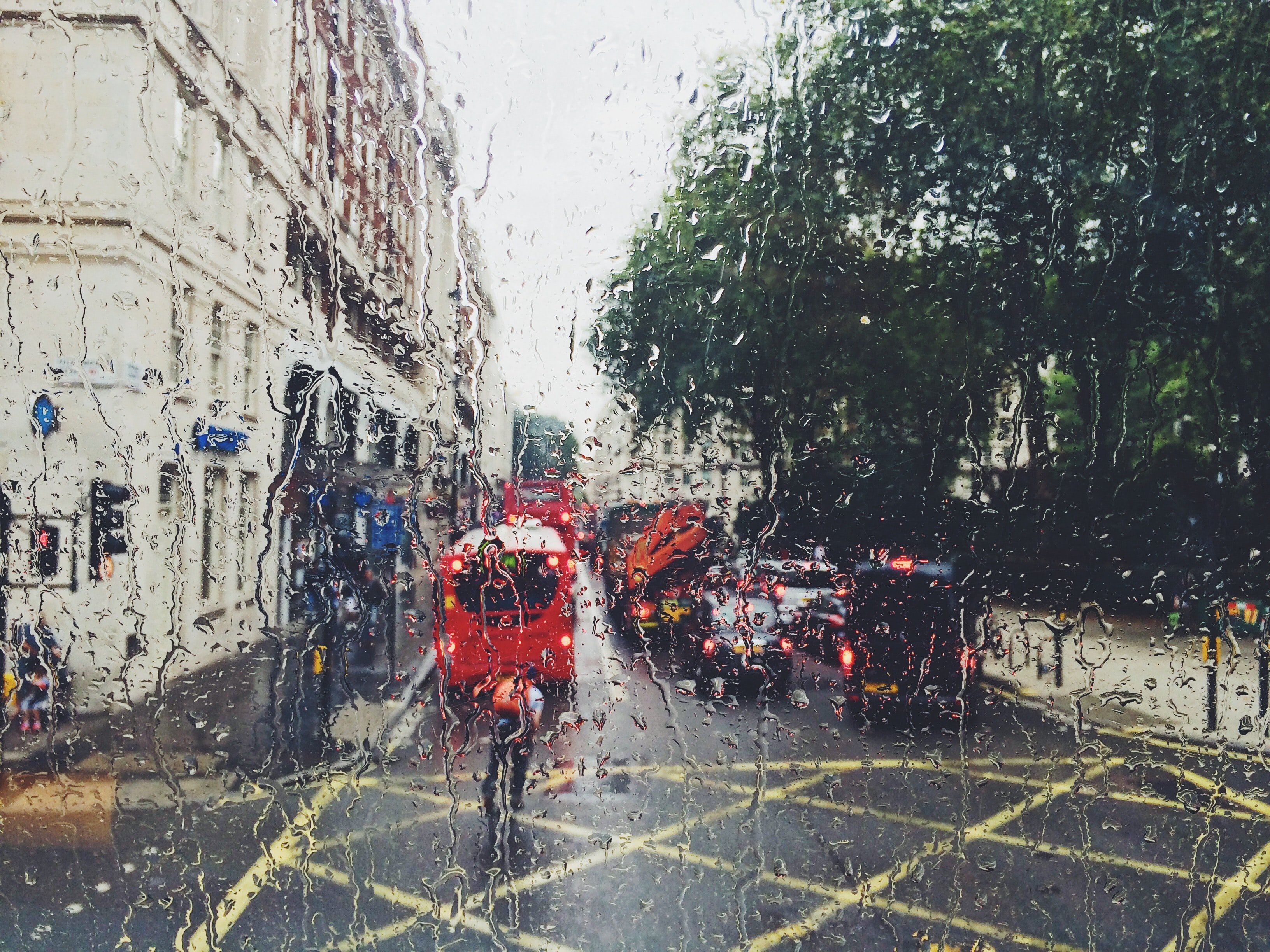 Un bus rouge dans une rue pluvieuse | Source: Unsplash