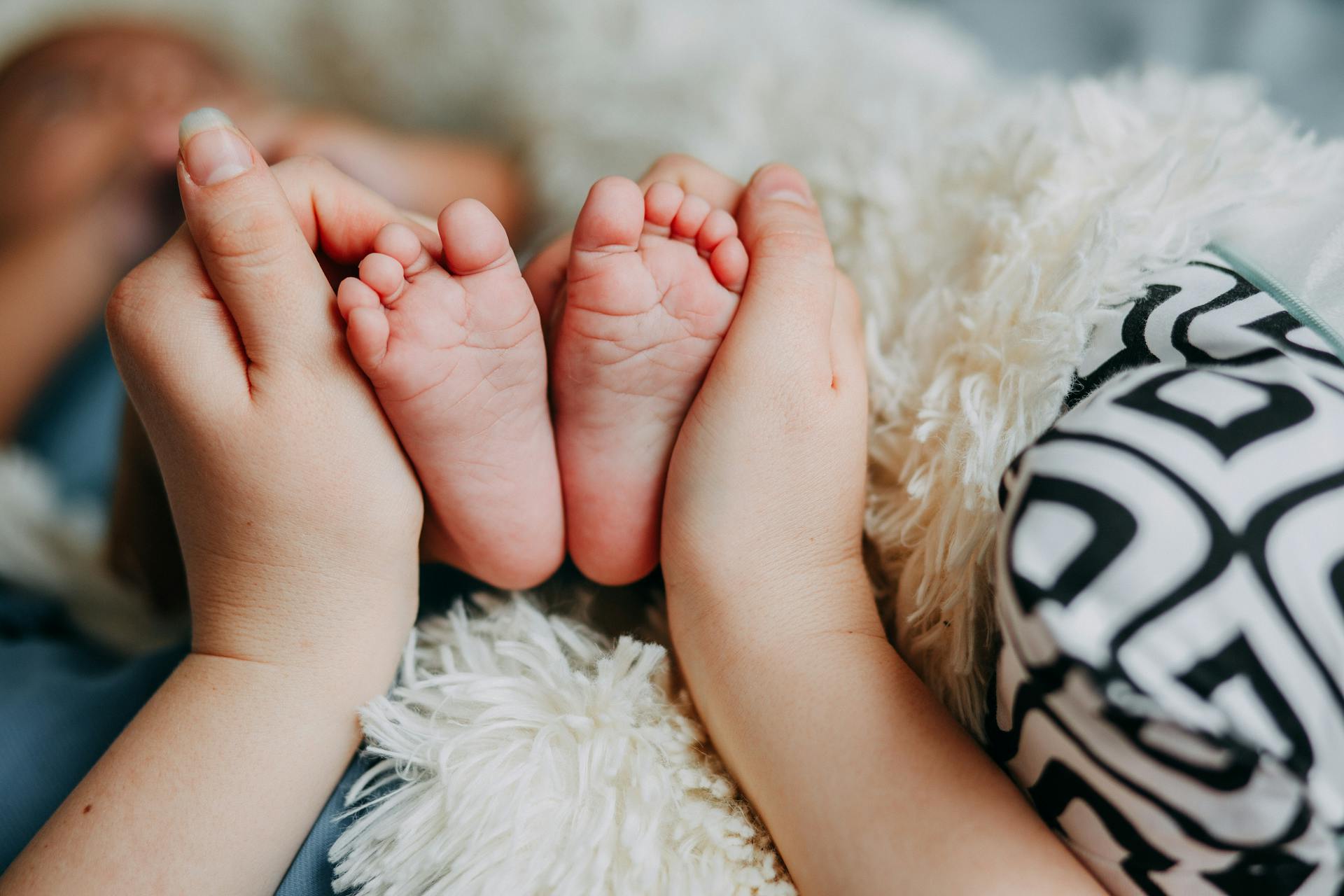 Une femme tenant les pieds de son bébé | Source : Pexels