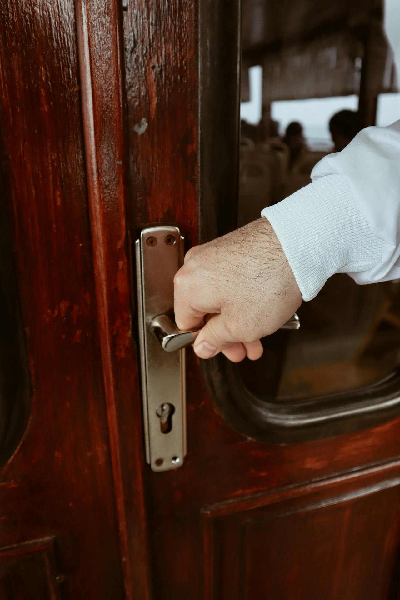 Prise de vue en gros plan d'un homme tenant une poignée de porte | Source : Pexels