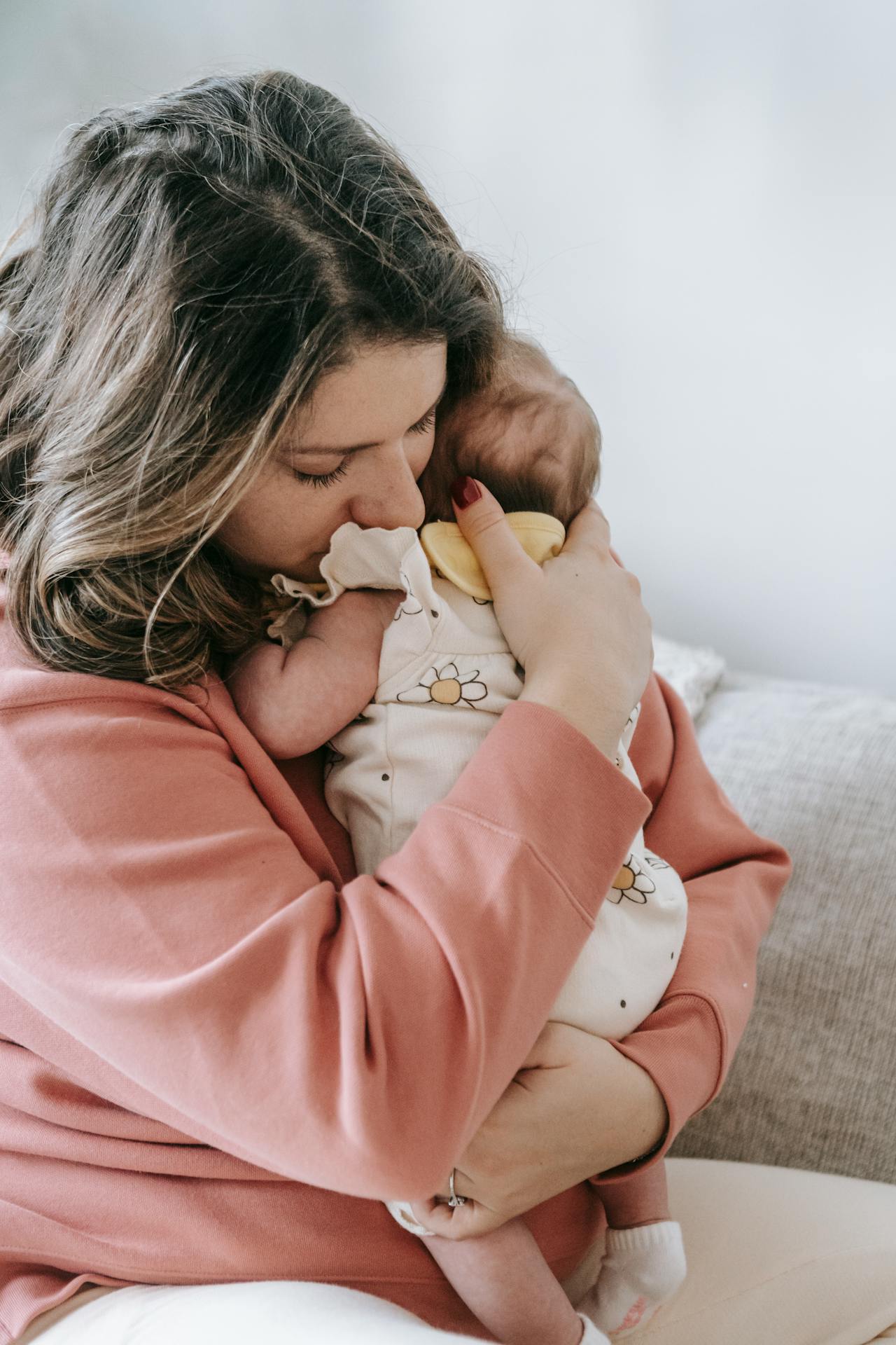 Une mère émue serrant son bébé contre elle | Source : Pexels