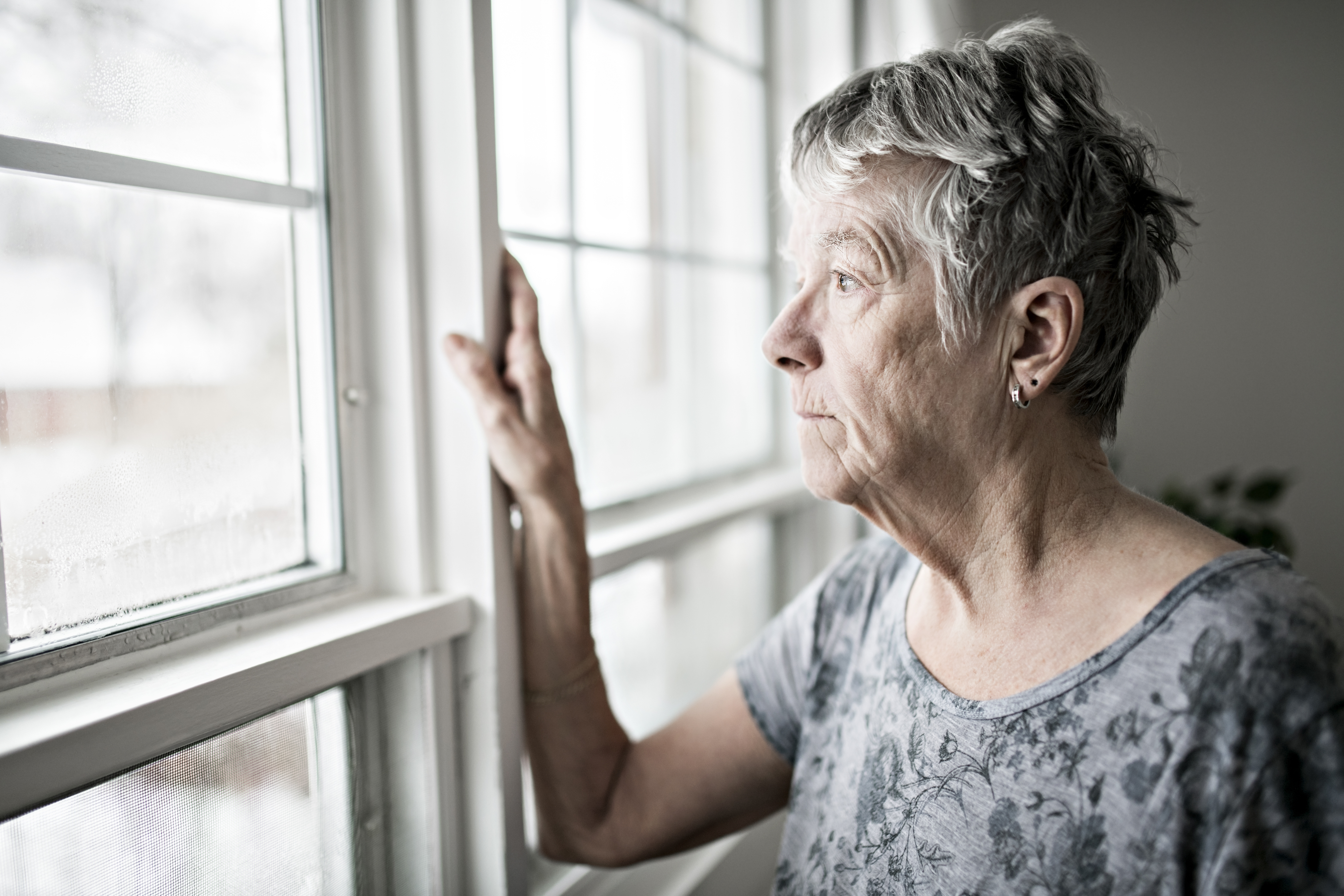 Femme âgée contrariée regardant par la fenêtre | Source : Getty Images