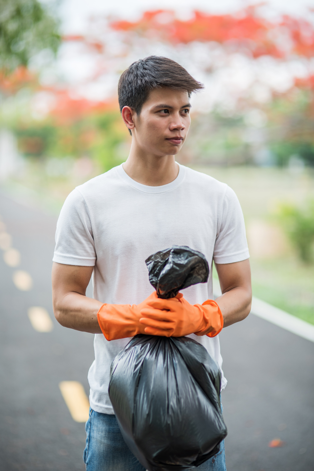 Un homme à l'extérieur tenant un sac poubelle | Source : Freepik