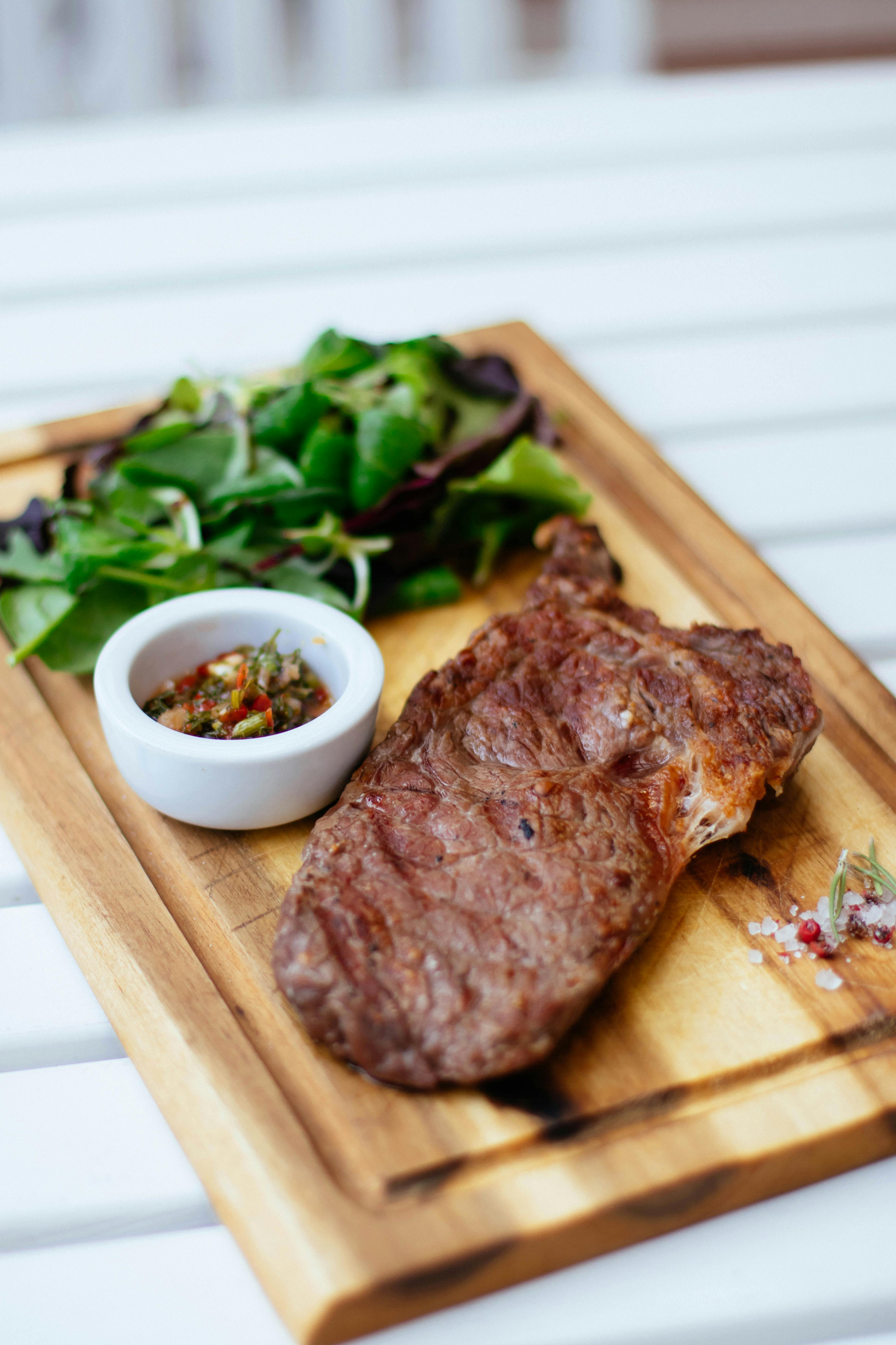 Un dîner de steak servi sur une planche en bois | Source : Pexels