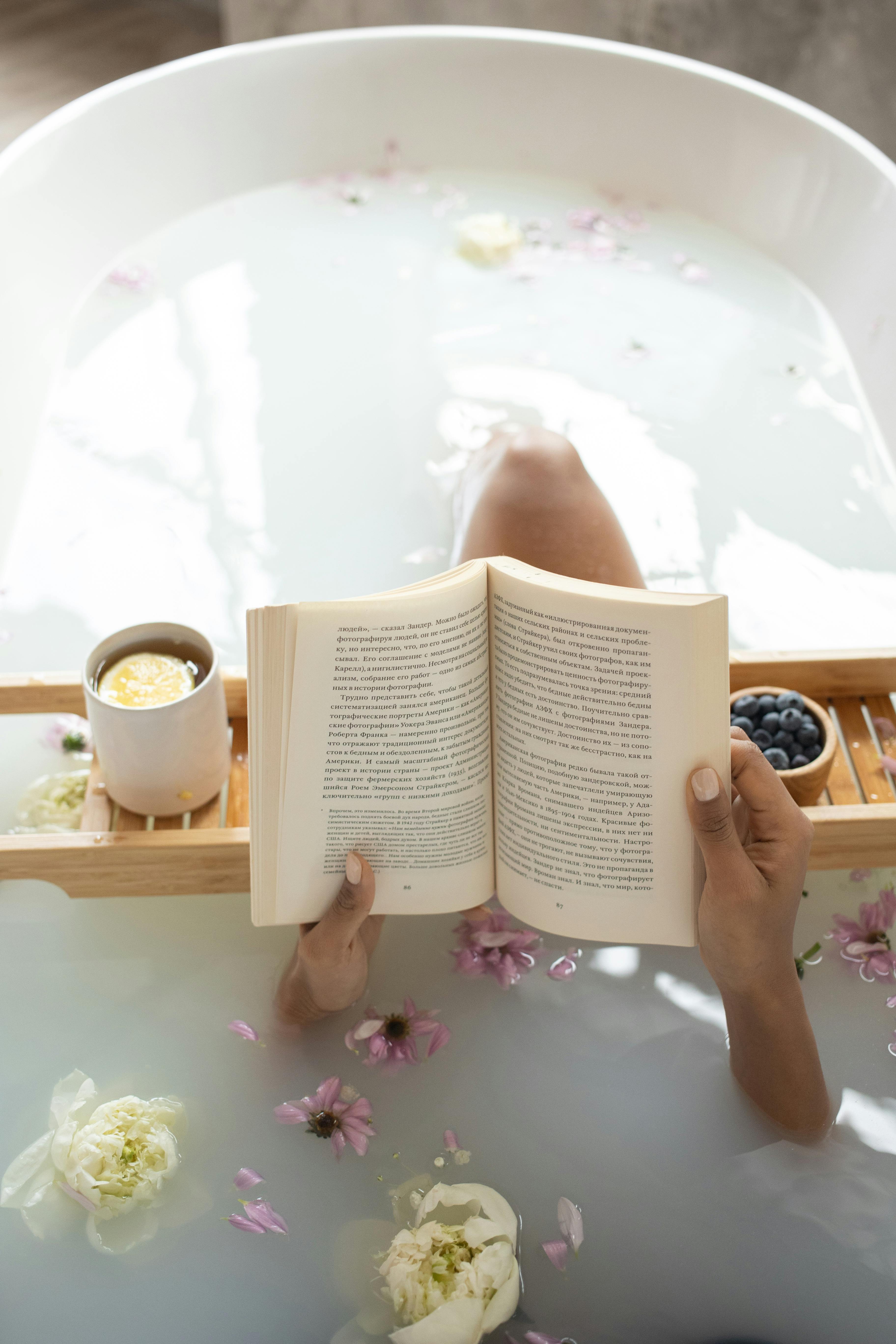 Une femme lisant un livre dans une baignoire pendant une cure thermale | Source : Pexels
