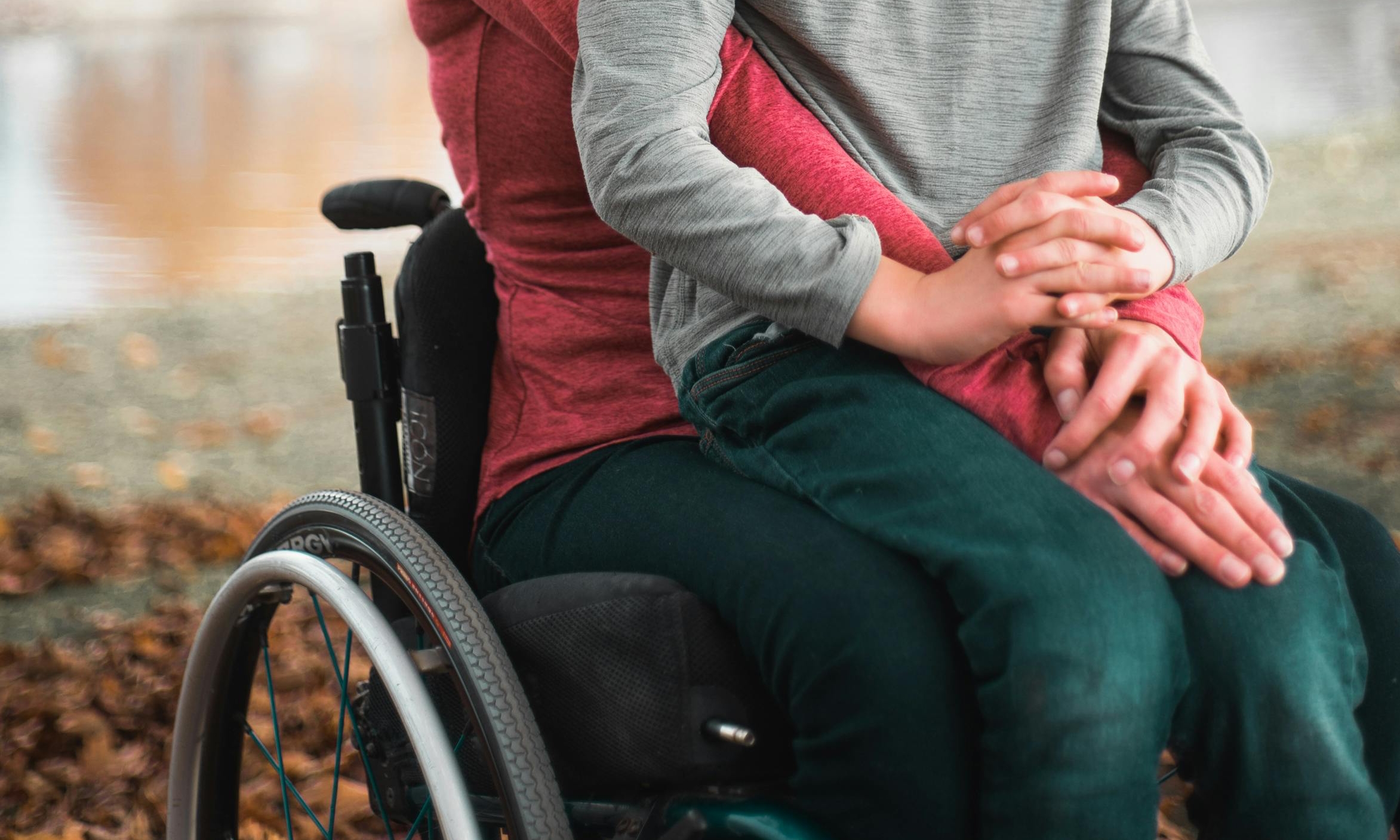 Une femme et un garçon sont assis ensemble dans un fauteuil roulant | Source : Pexels