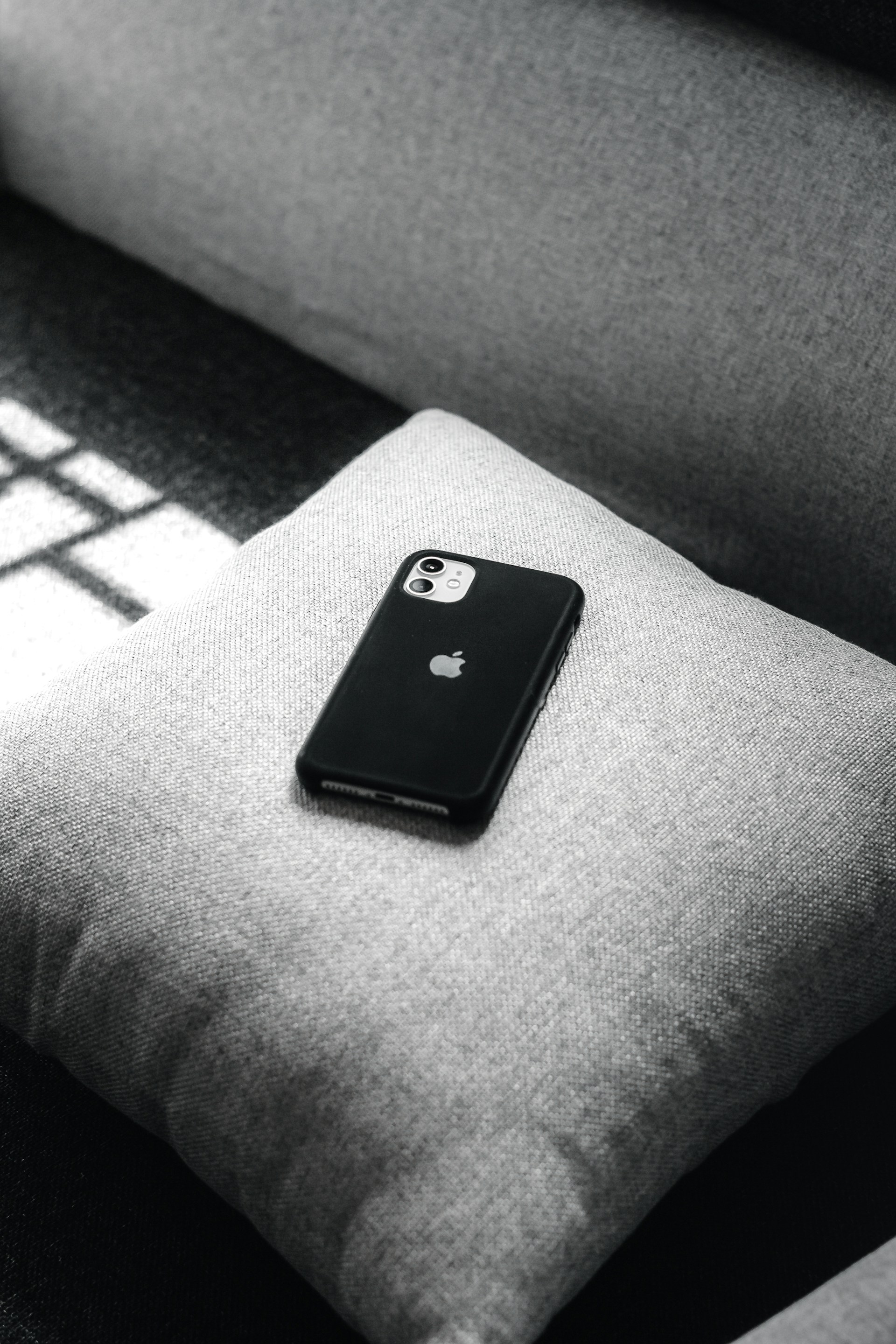 Un téléphone sur un coussin de canapé | Source : Unsplash