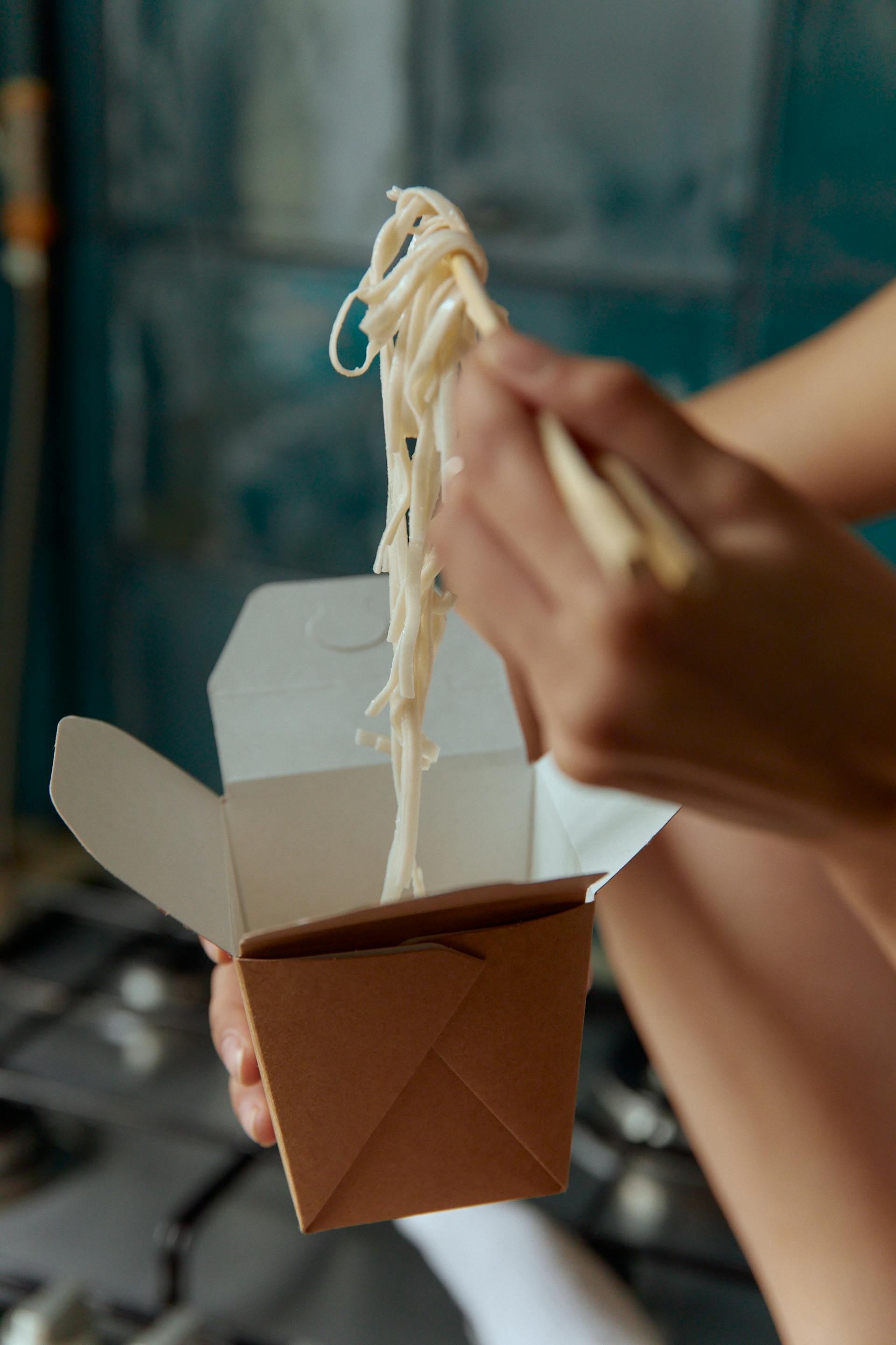 Une femme mangeant des plats chinois à emporter | Source : Pexels