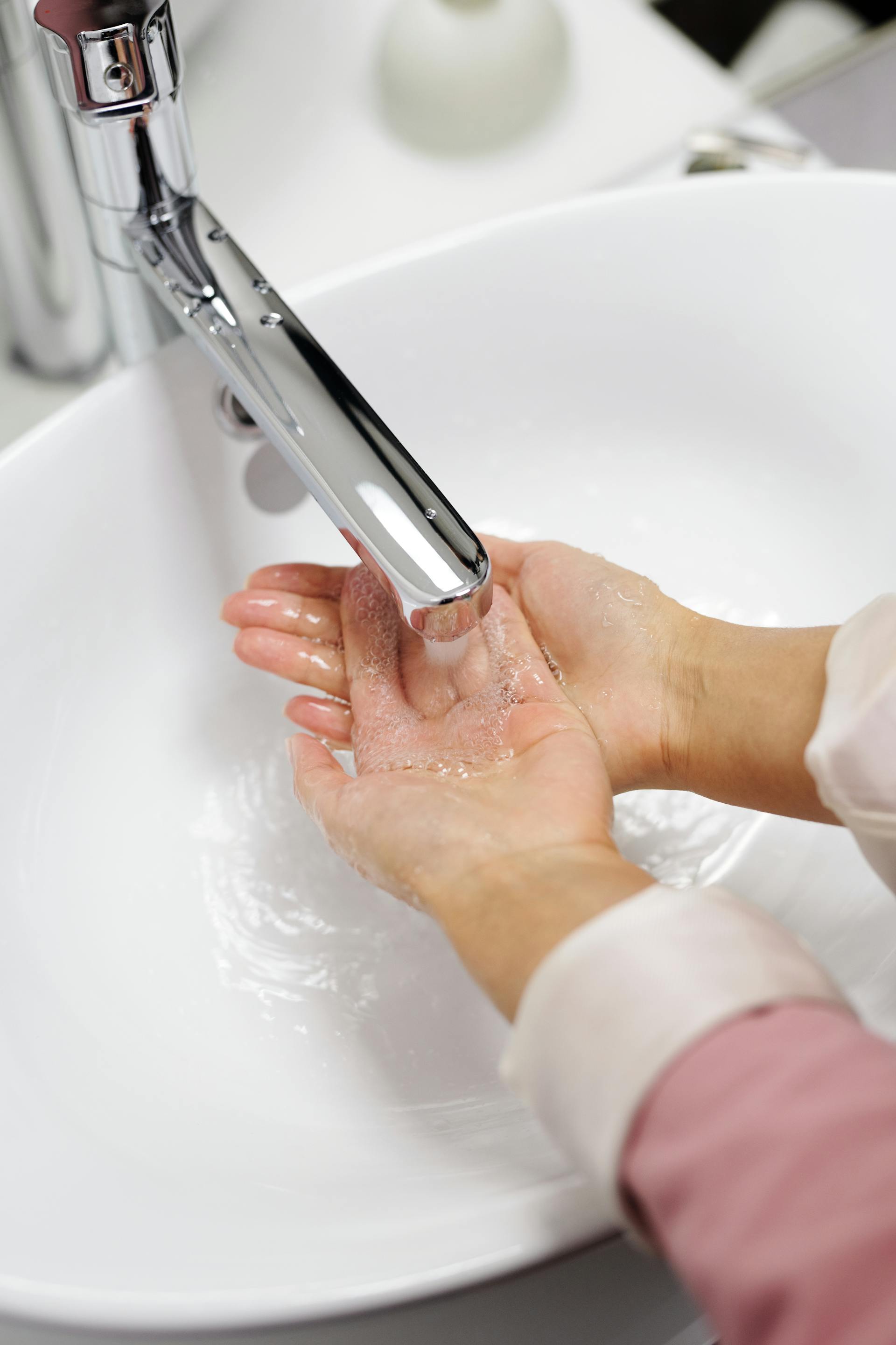 Les mains sous un robinet qui coule | Source : Pexels