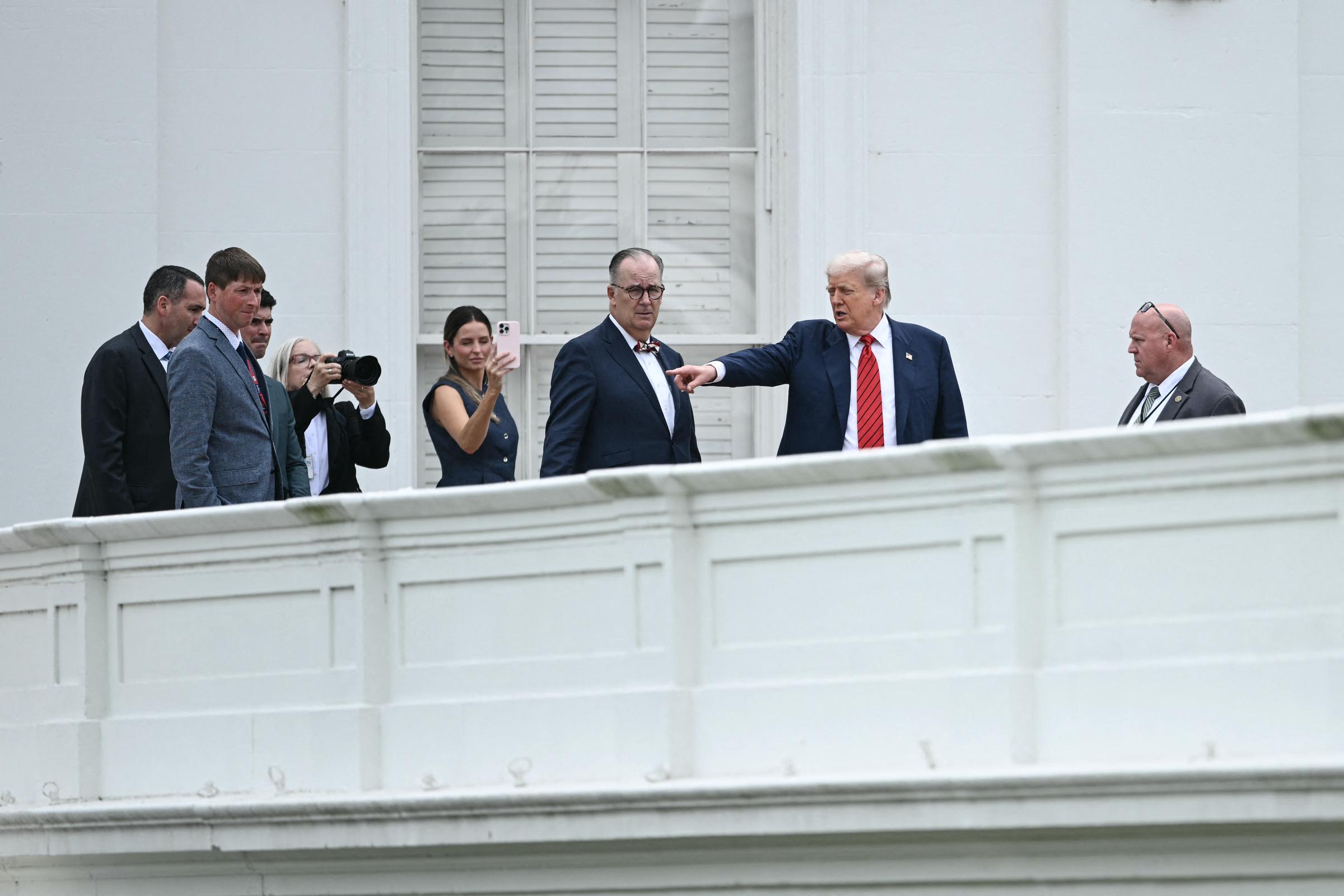Accompagné de l'architecte James C. McCrery et d'assistants, Donald Trump pointe du doigt le toit de la Maison Blanche lors de sa visite des toits, soulignant les zones prévues pour la rénovation tandis que les caméras capturent la scène rare.