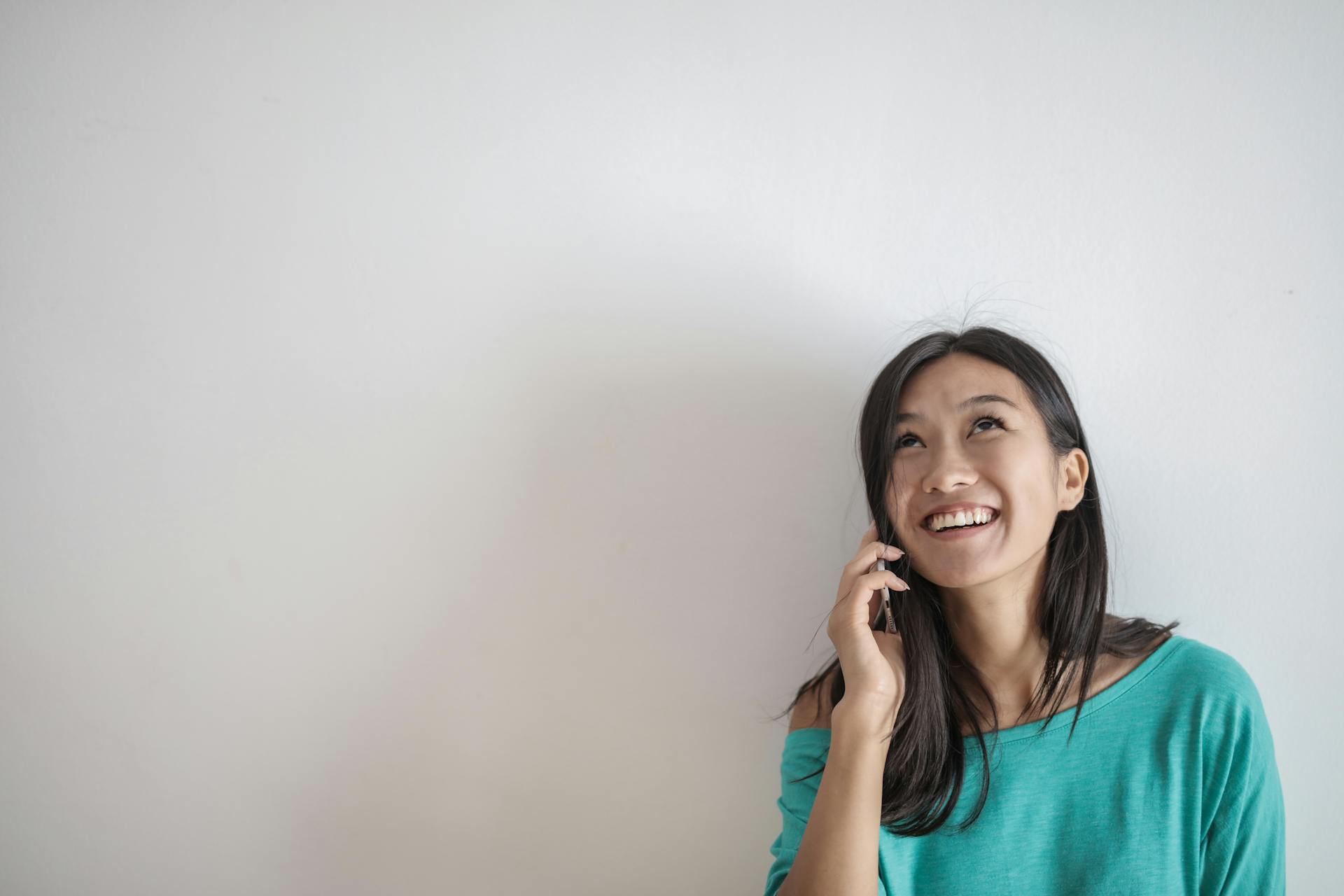 Une femme qui sourit pendant un appel téléphonique | Source : Pexels