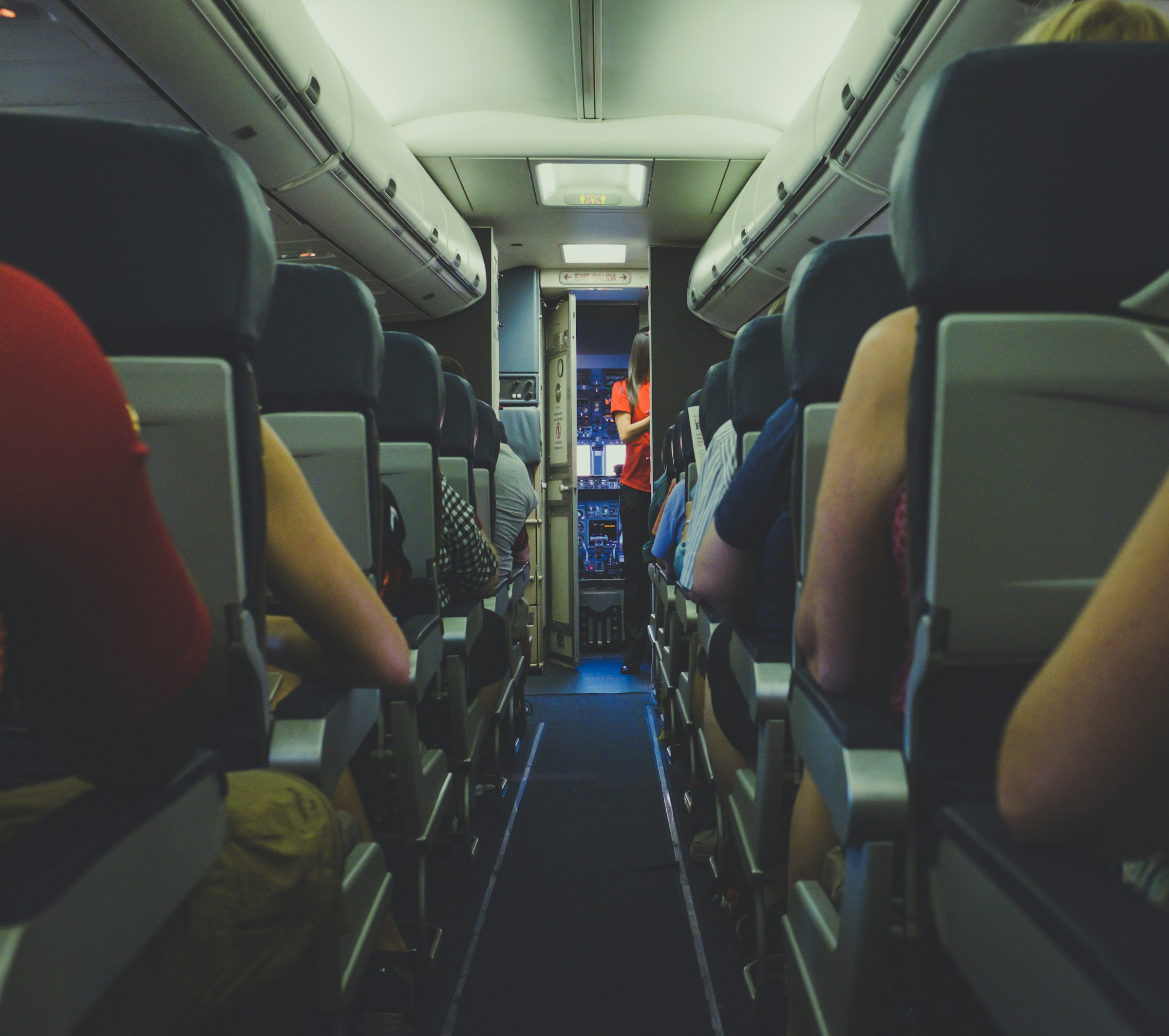 A flight attendant and passengers in the front of the plane | Source: Unsplash