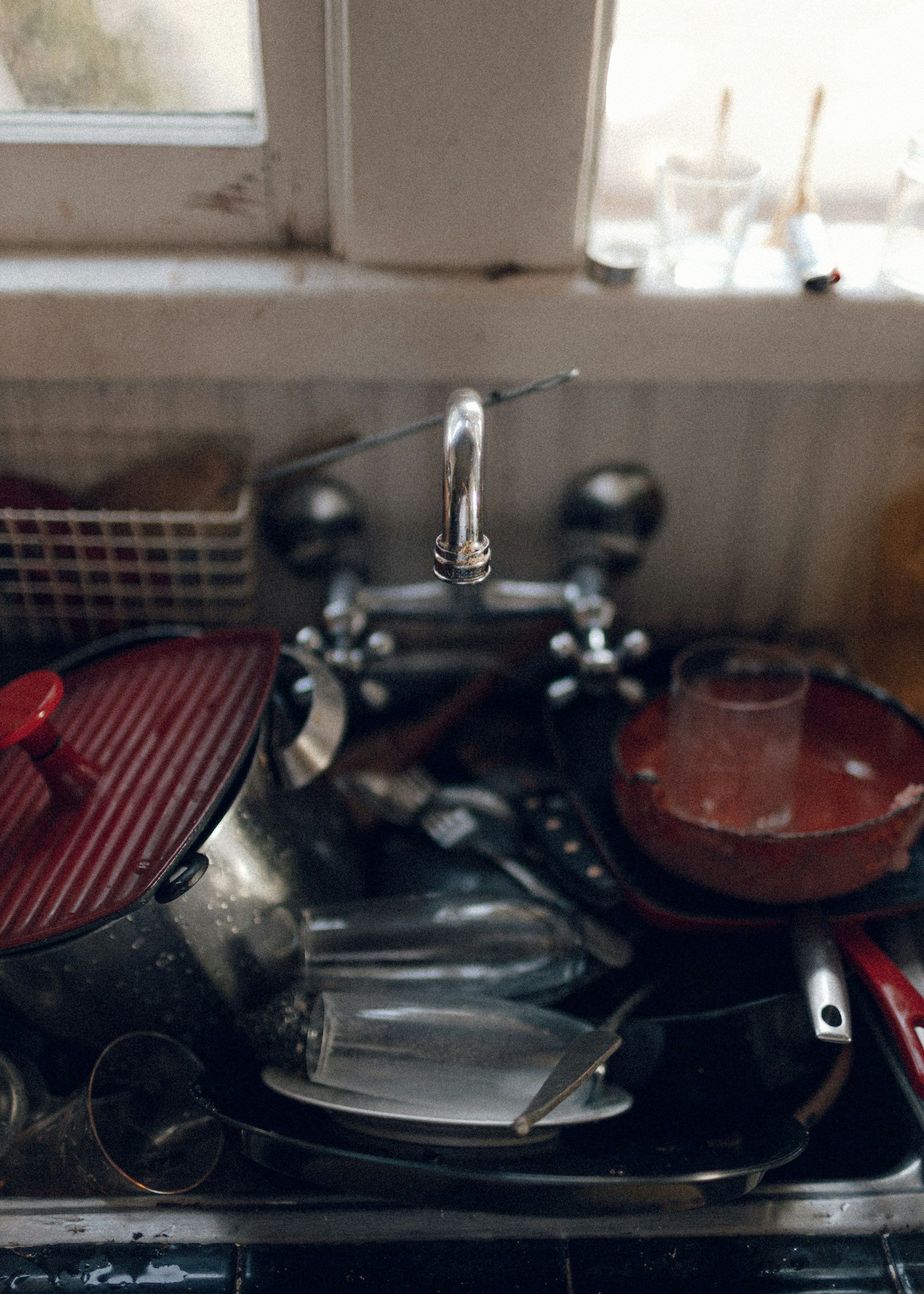 Un évier de cuisine débordant de vaisselle sale | Source : Unsplash