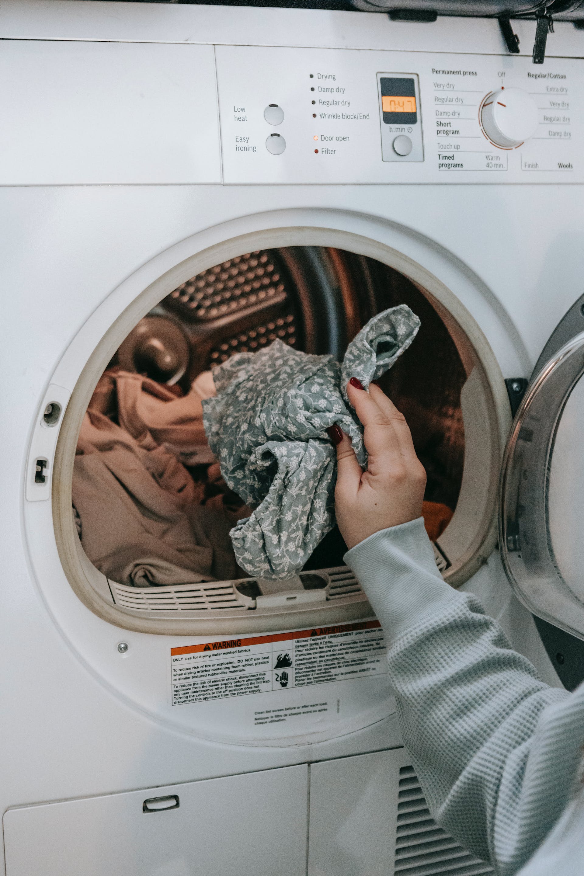 Personne mettant des vêtements dans une machine à laver | Source : Pexels