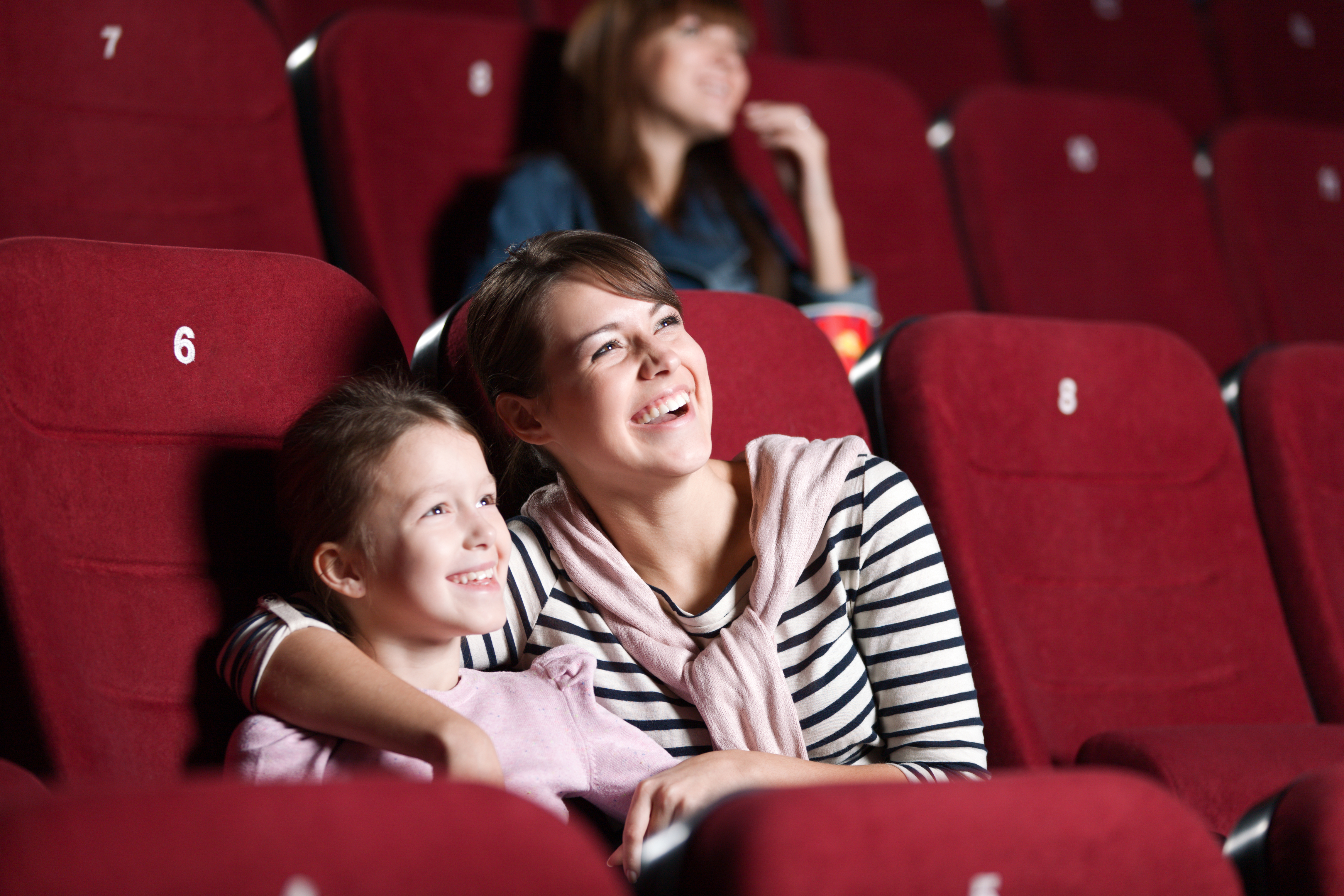 Une mère et sa fille s'amusent dans une salle de cinéma | Source : Shutterstock
