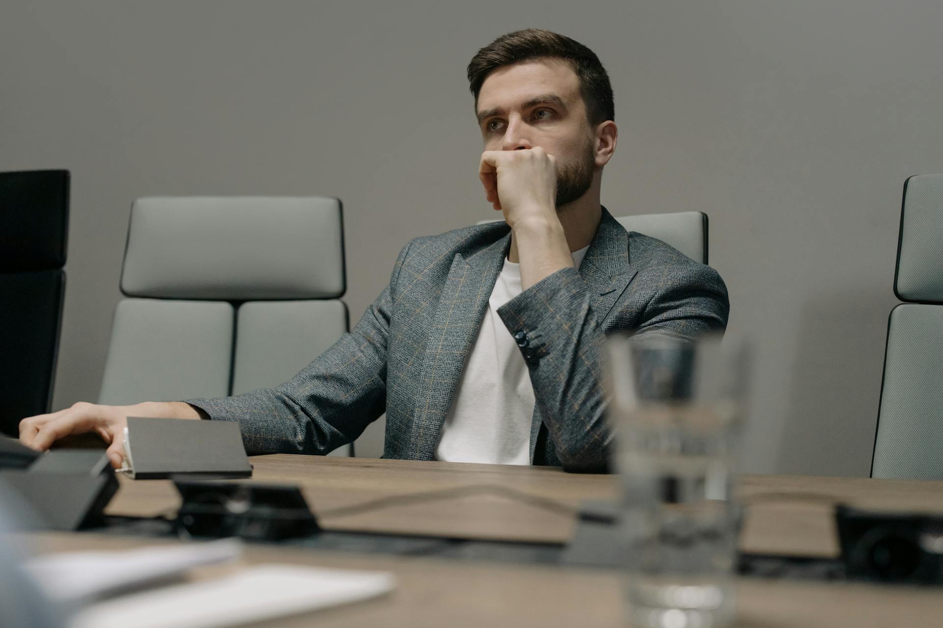 Un homme a l'air pensif alors qu'il est assis dans son bureau | Source : Pexels