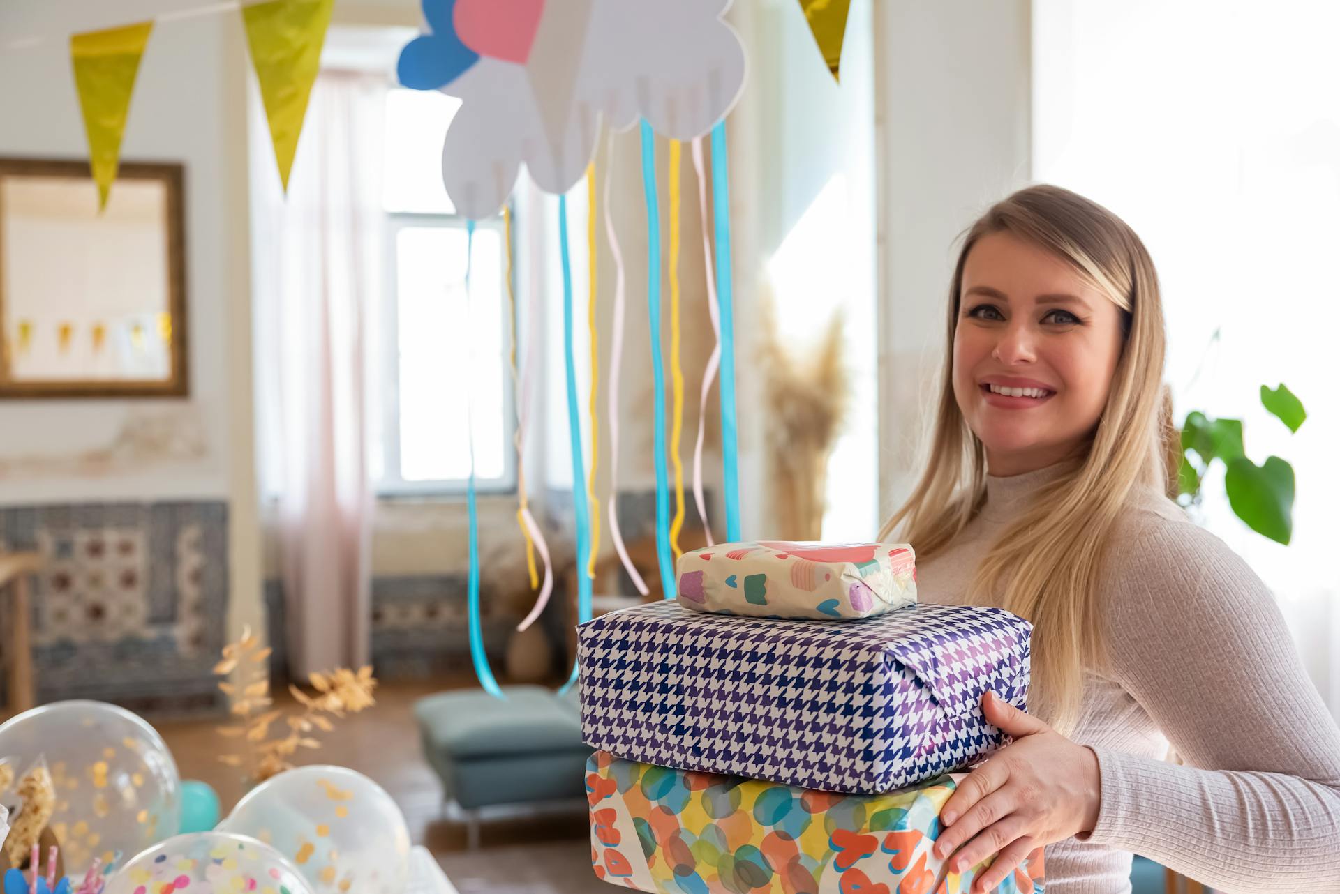 Une femme tenant une pile de cadeaux lors d'une fête prénatale | Source : Pexels