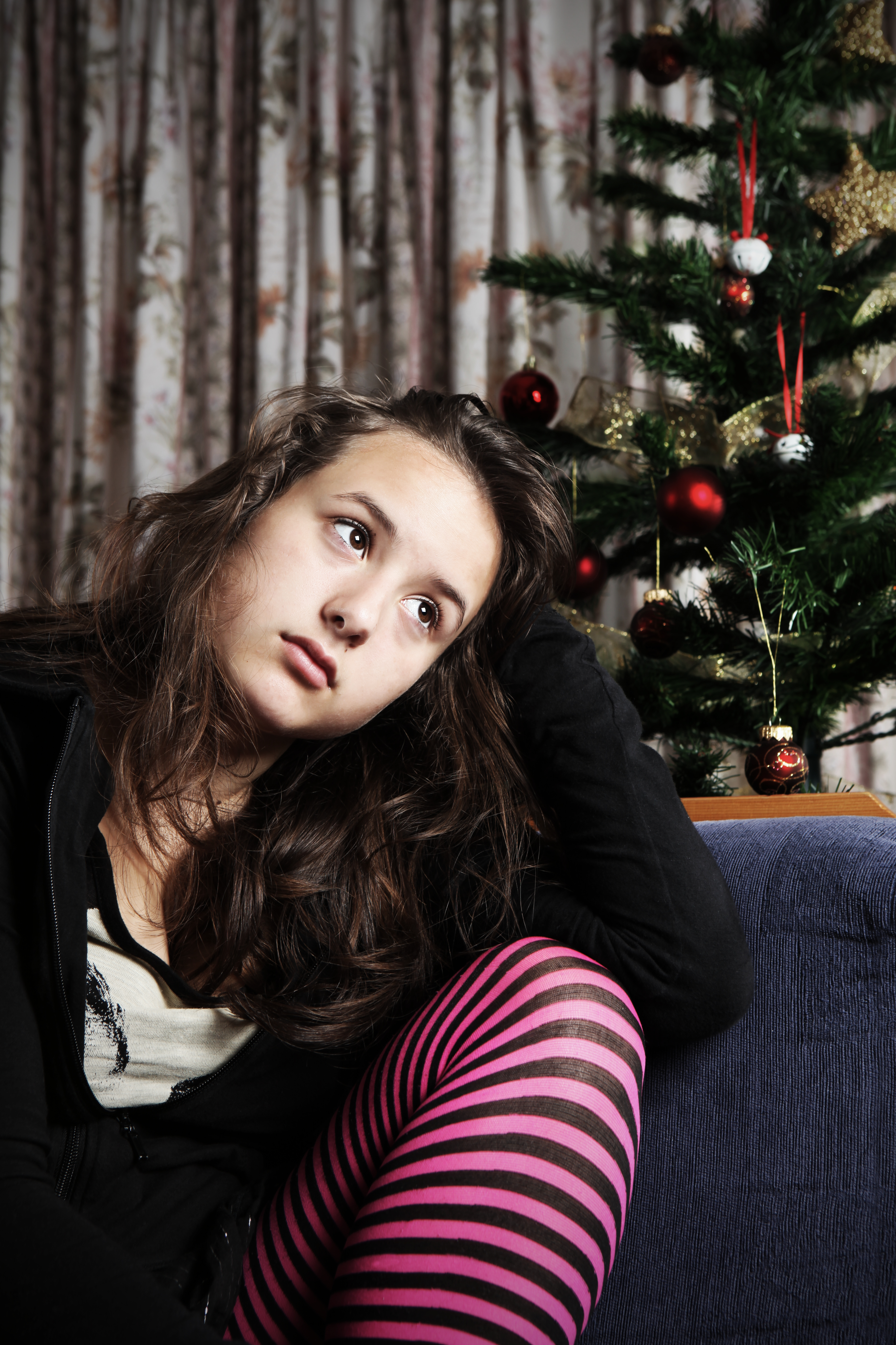 Une femme triste assise à côté d'un sapin de Noël | Source : Getty Images