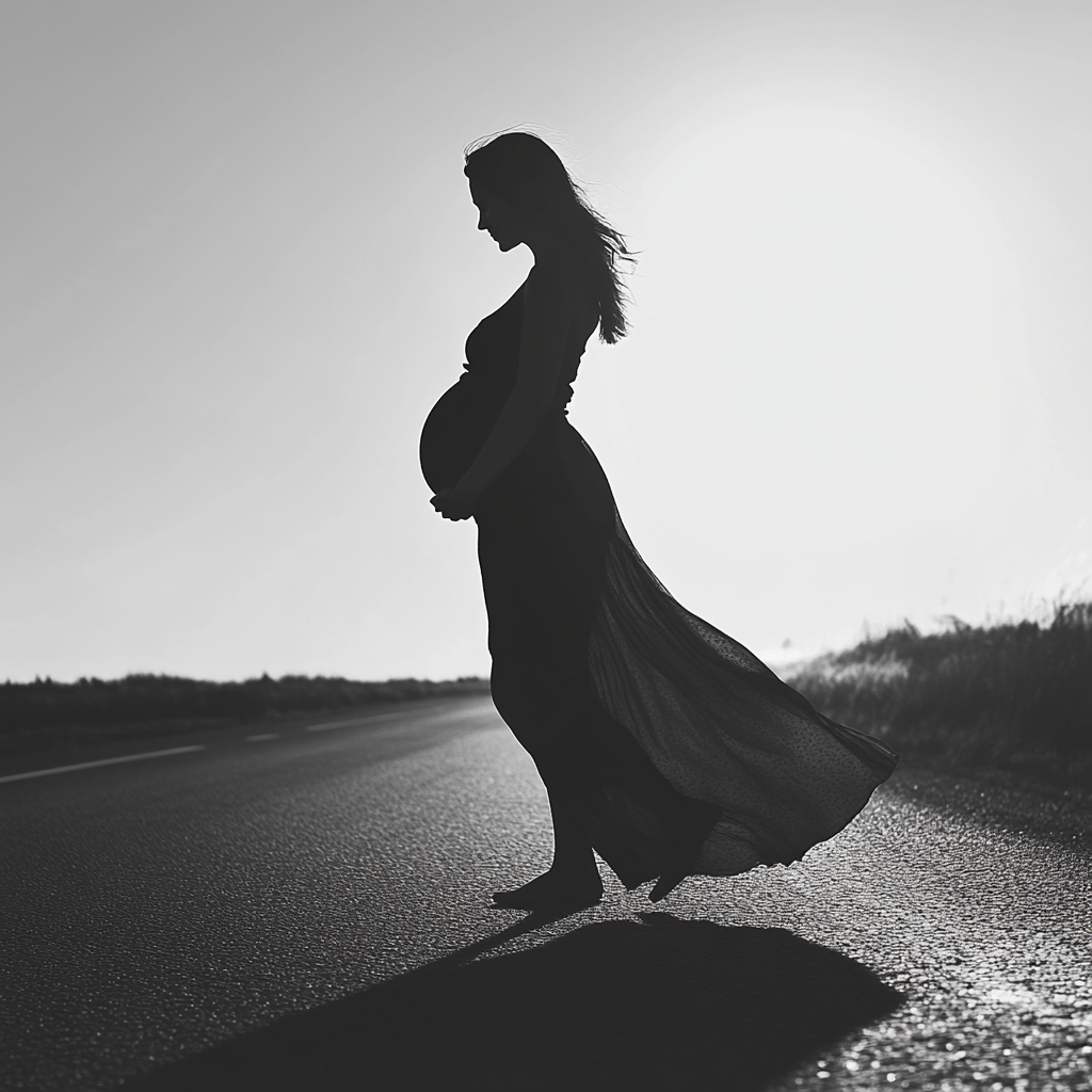 Plan en niveaux de gris d'une femme enceinte sur la route | Source : Midjourney