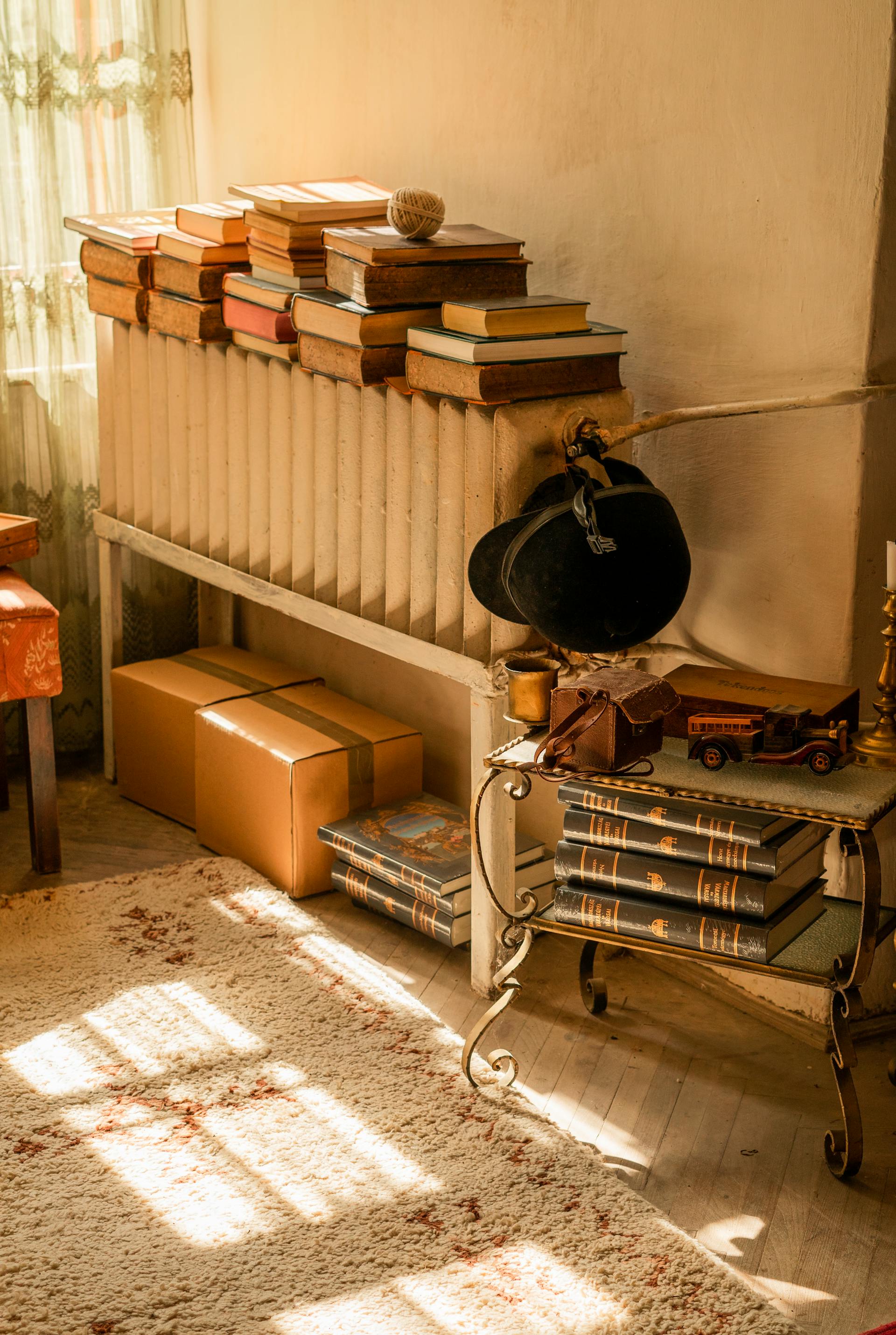 Des piles de livres et de vieilles boîtes gisant dans le coin d'une pièce | Source : Pexels