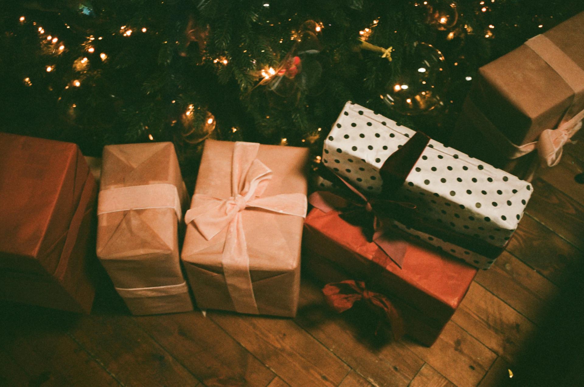Boîtes de cadeaux posés sur le sol près d'un arbre de Noël | Source : Pexels
