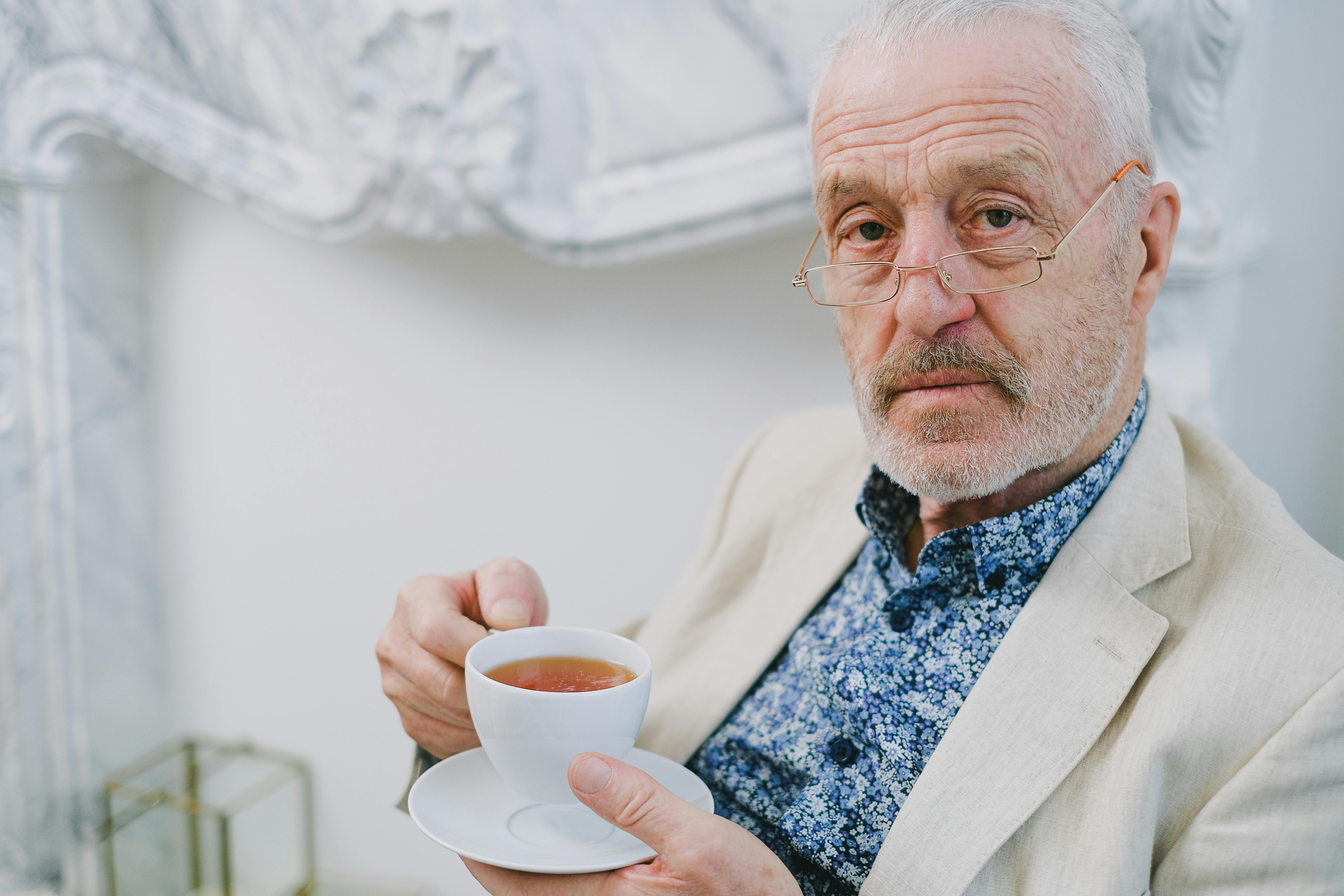 Un homme sérieux tenant une tasse de thé | Source : Pexels