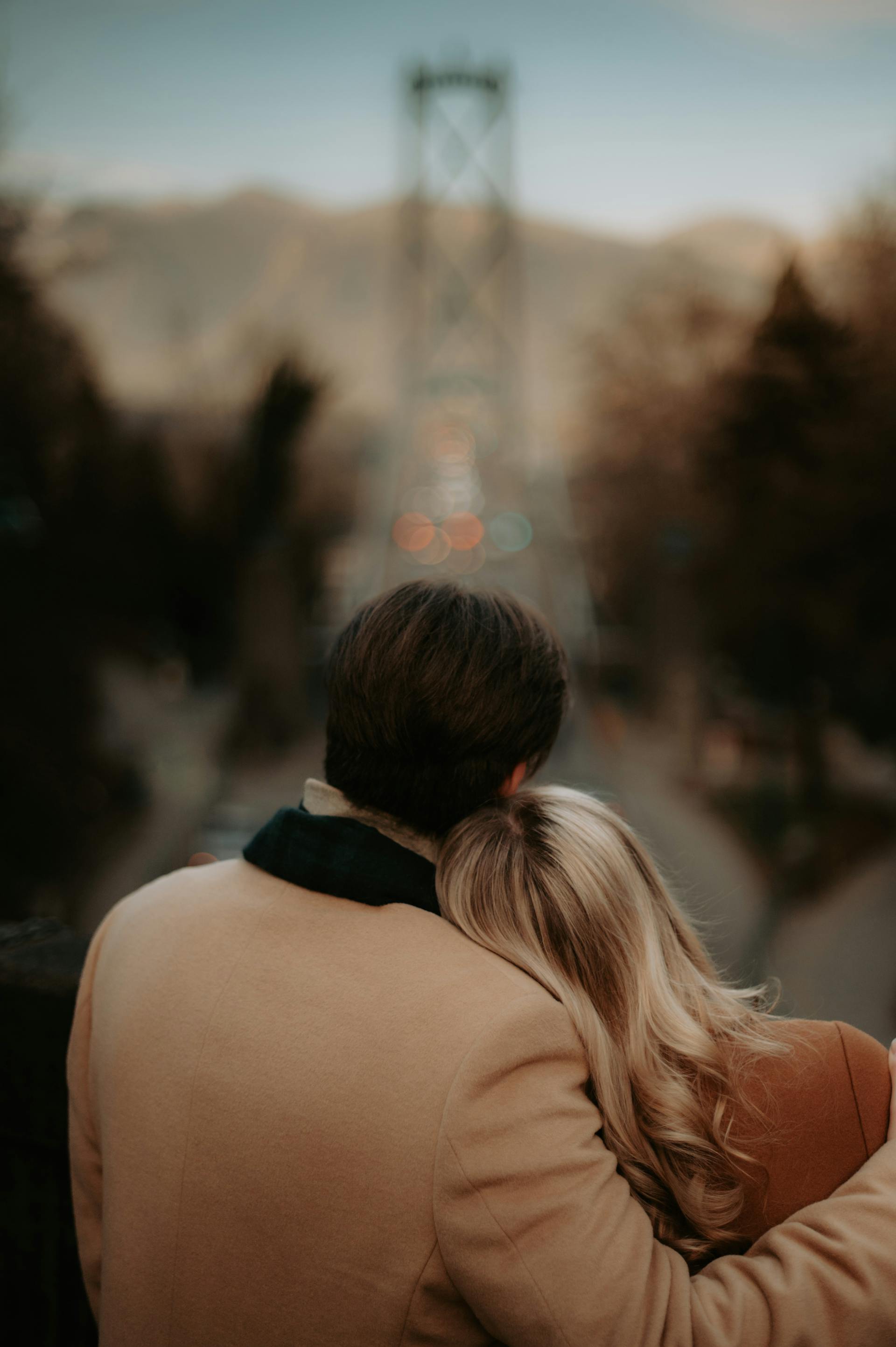 Un homme embrassant une femme sur un paysage urbain flou | Source : Pexels