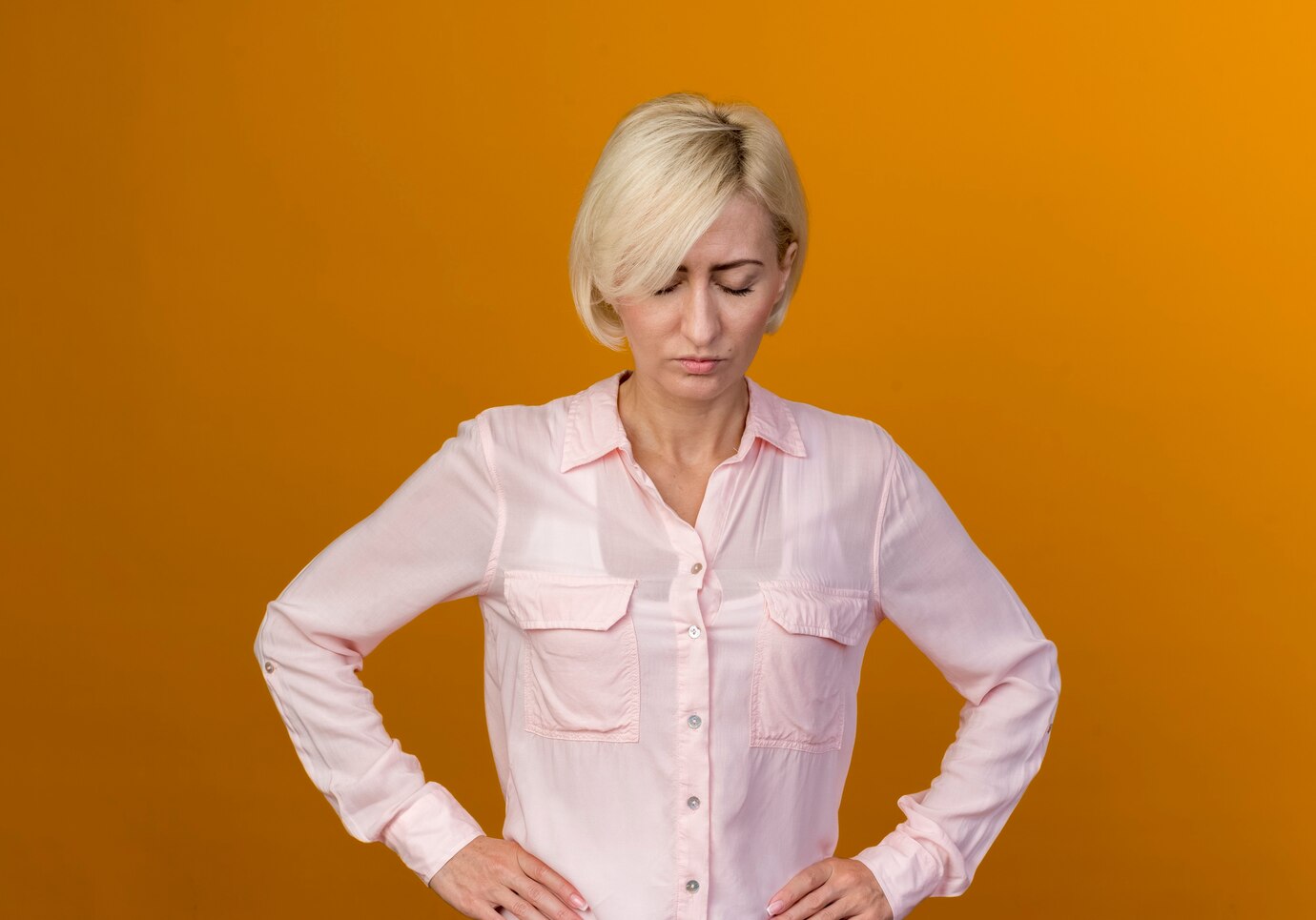 Une femme mature et triste qui regarde vers le bas | Source : Freepik