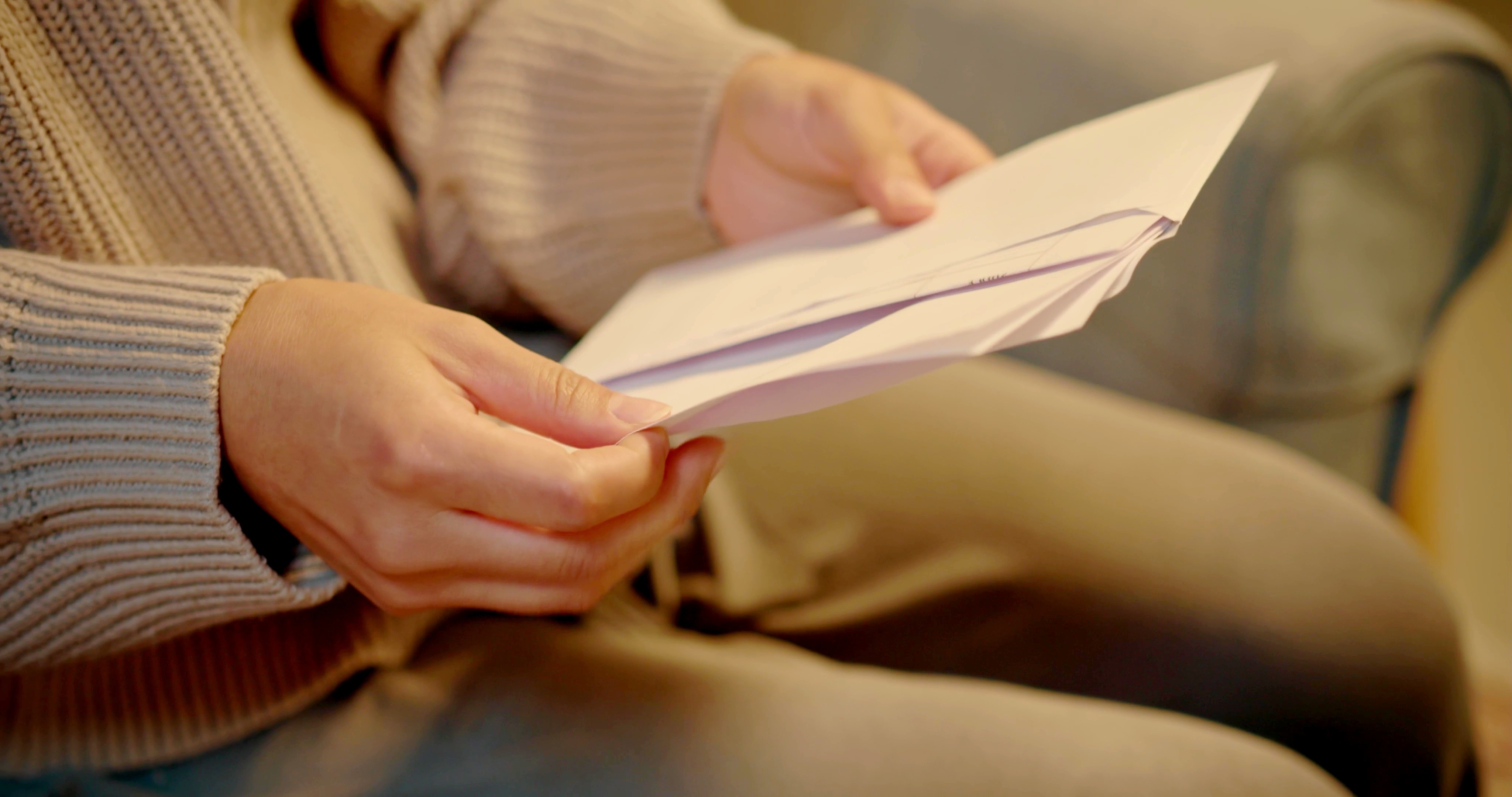 Femme ouvrant une enveloppe | Source : Shutterstock