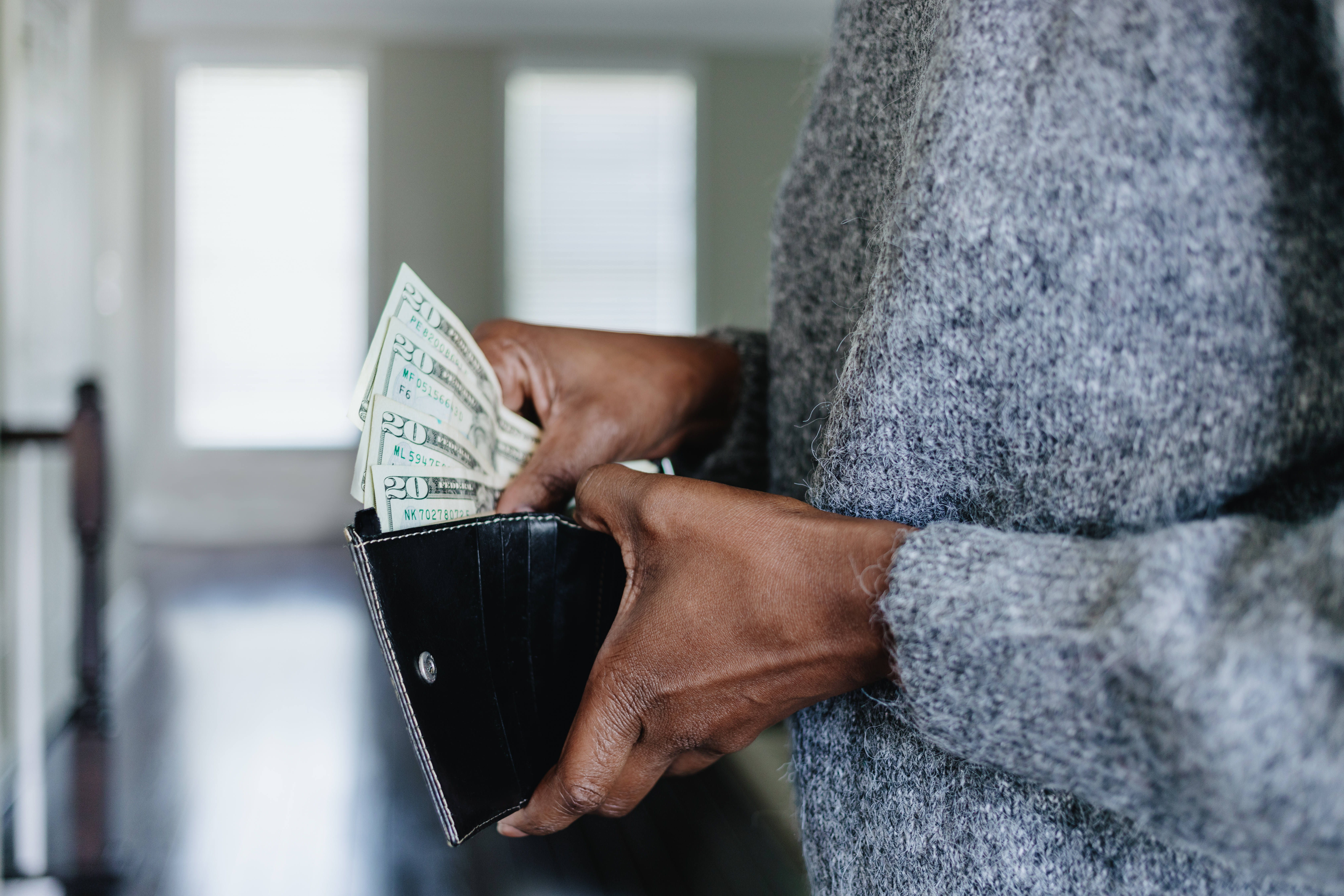 Femme mettant de l'argent dans son portefeuille | Source : Getty Images