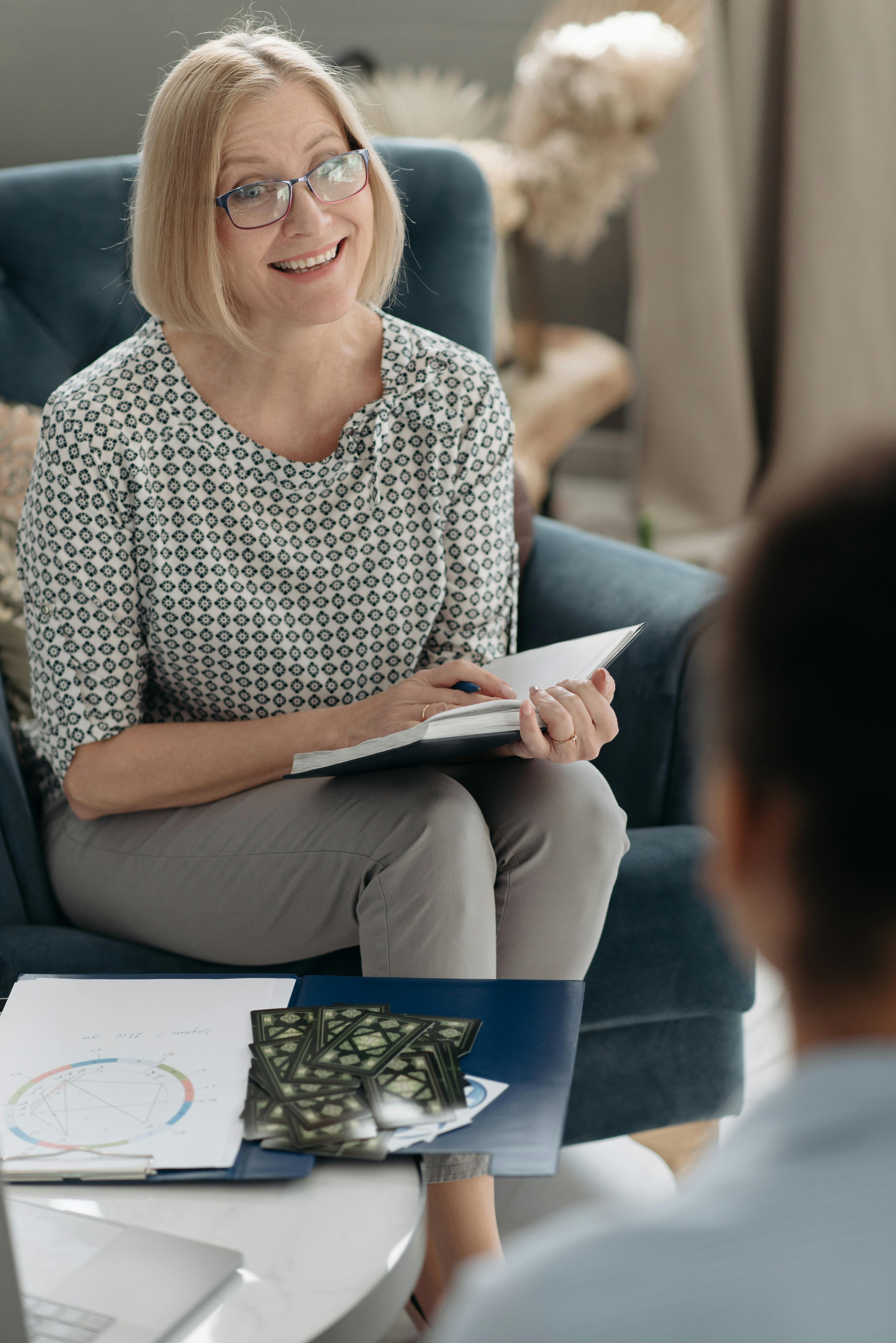 Une femme tenant un livre tout en parlant à quelqu'un | Source : Pexels