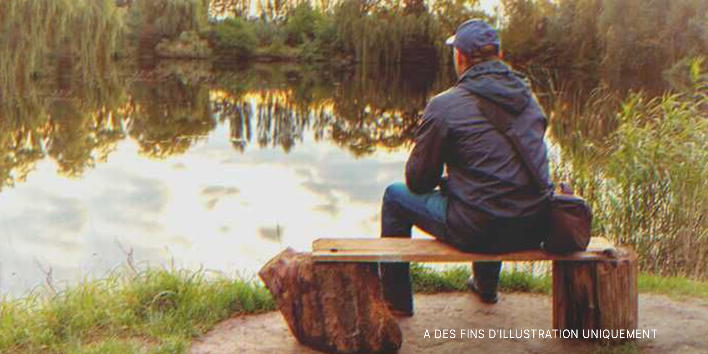 Un homme assis devant un lac | Source : Shutterstock