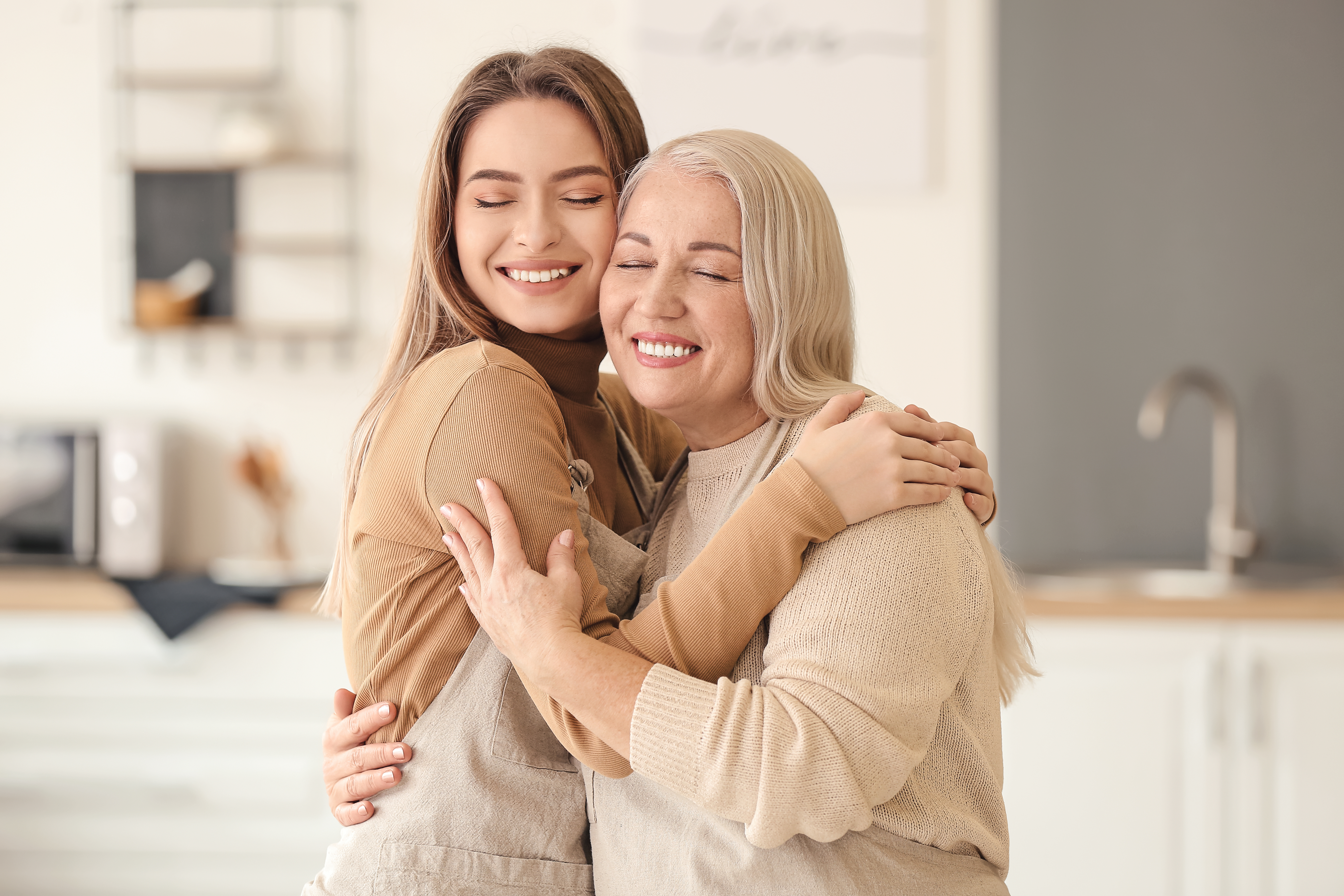 Une femme plus jeune serre sa maman âgée dans ses bras | Source : Shutterstock