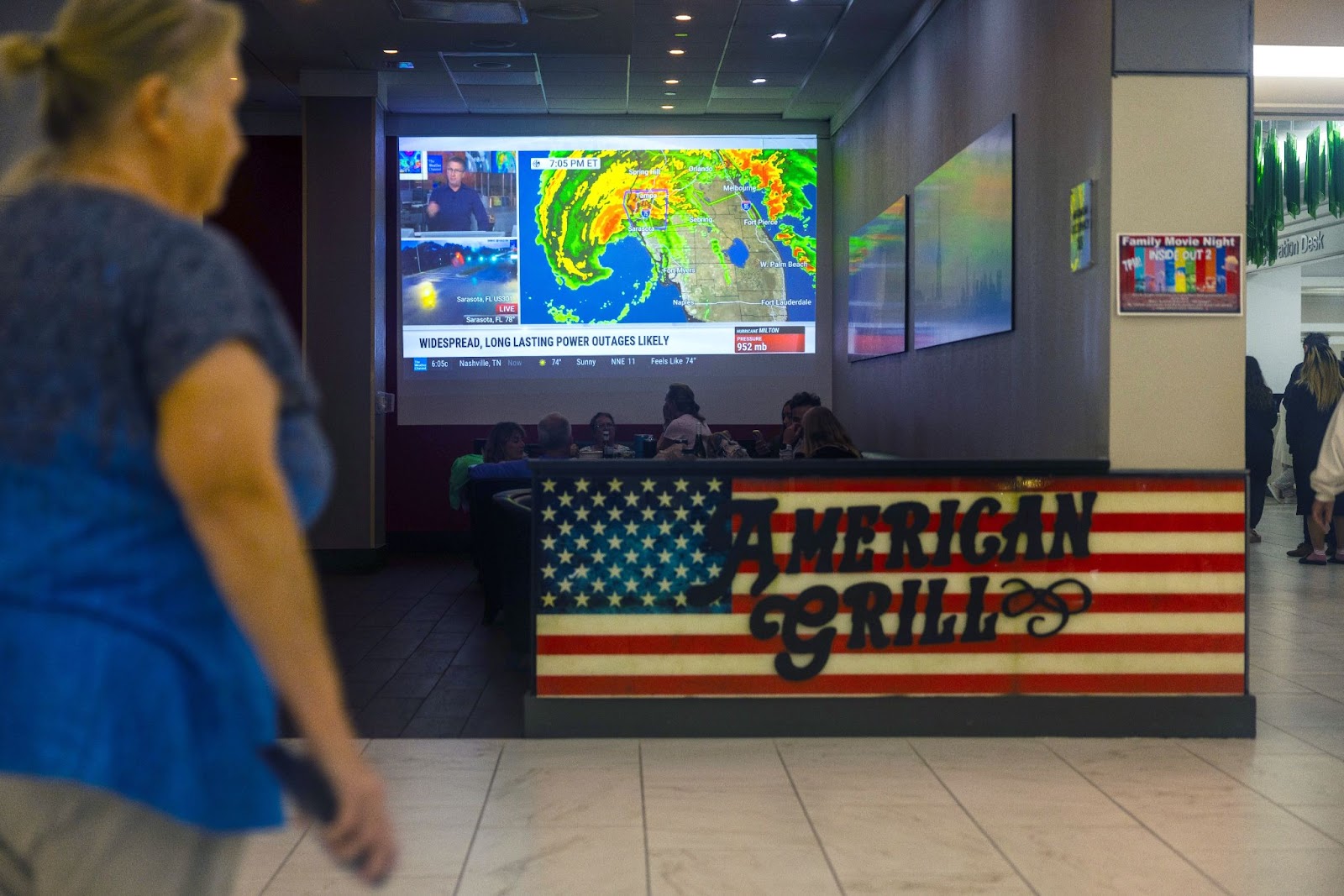 Des personnes regardent le bulletin météo avant le passage de l'ouragan Milton. | Source : Getty Images