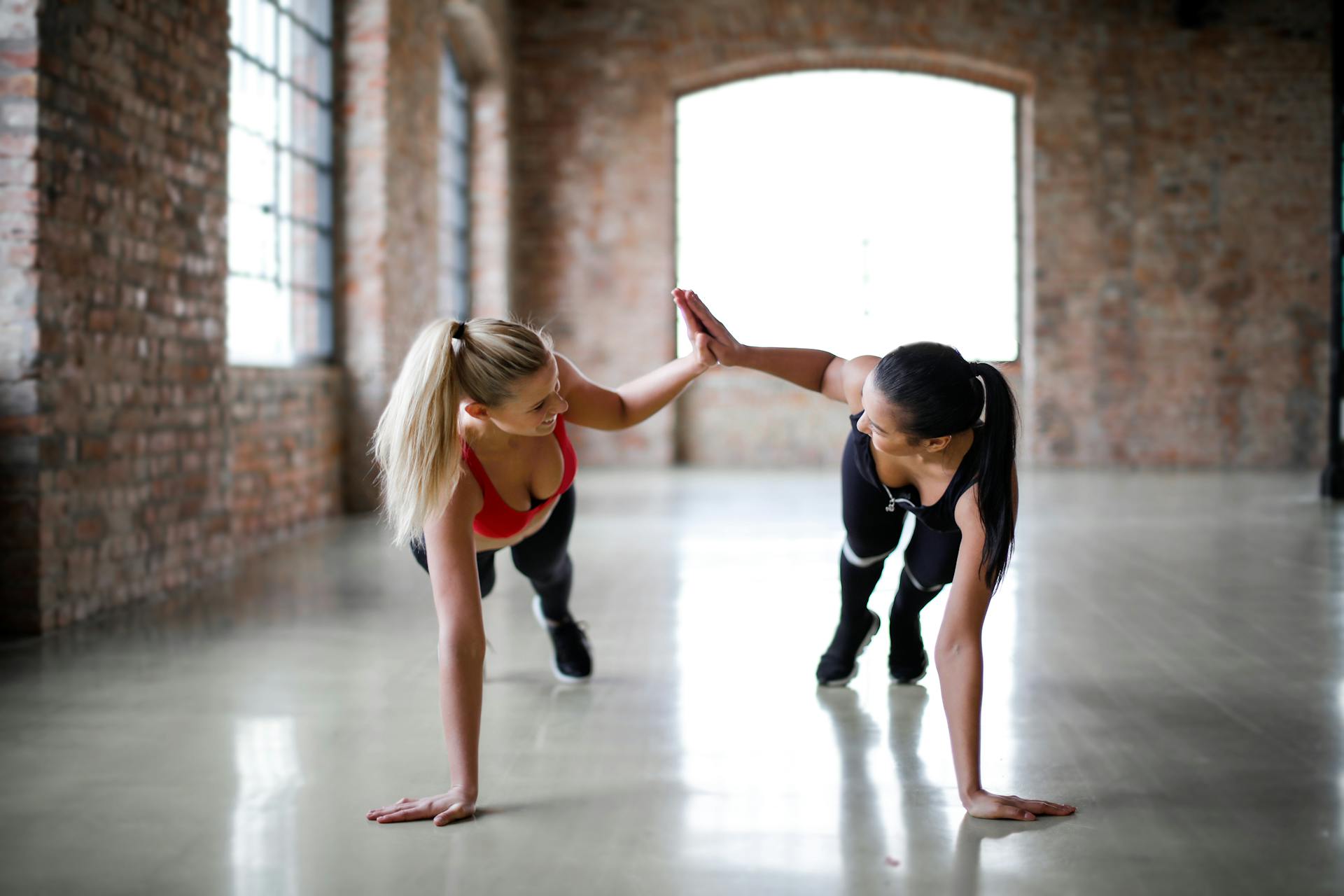 Deux femmes se faisant un high-five pendant qu'elles s'entraînent ensemble | Source : Pexels