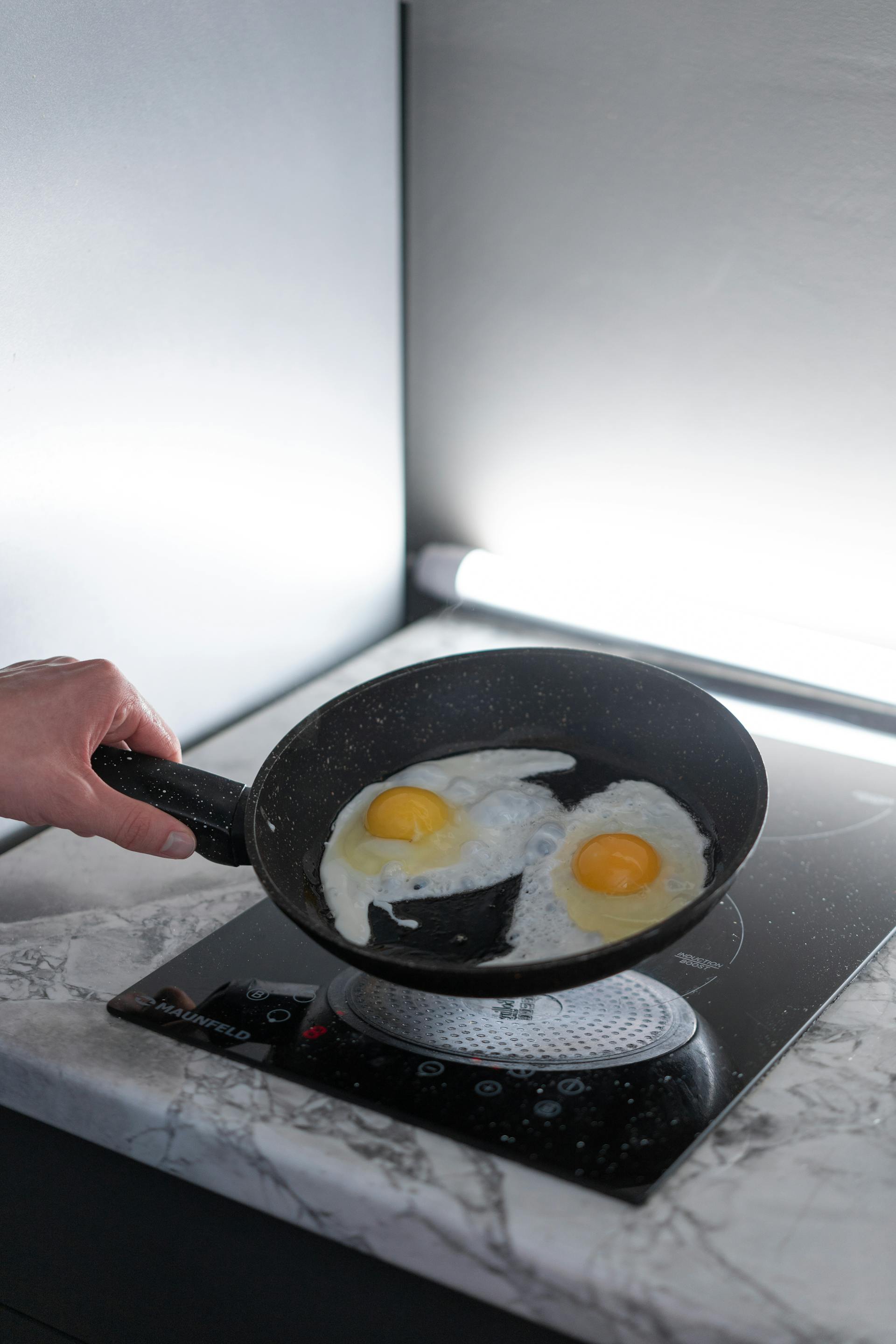 Gros plan d'une personne tenant une casserole avec des œufs cuits | Source : Pexels